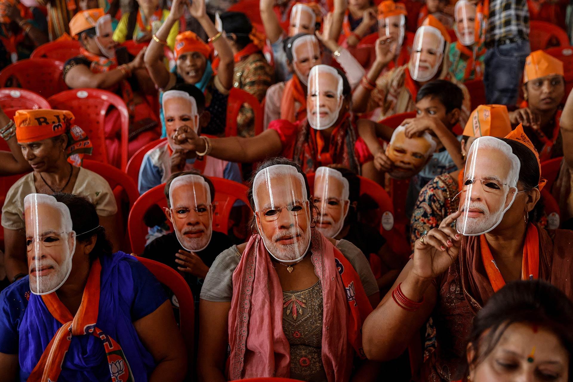 Seguidores del primer ministro de la India, Narendra Modi, usan máscaras de su cara en un mitin de campaña