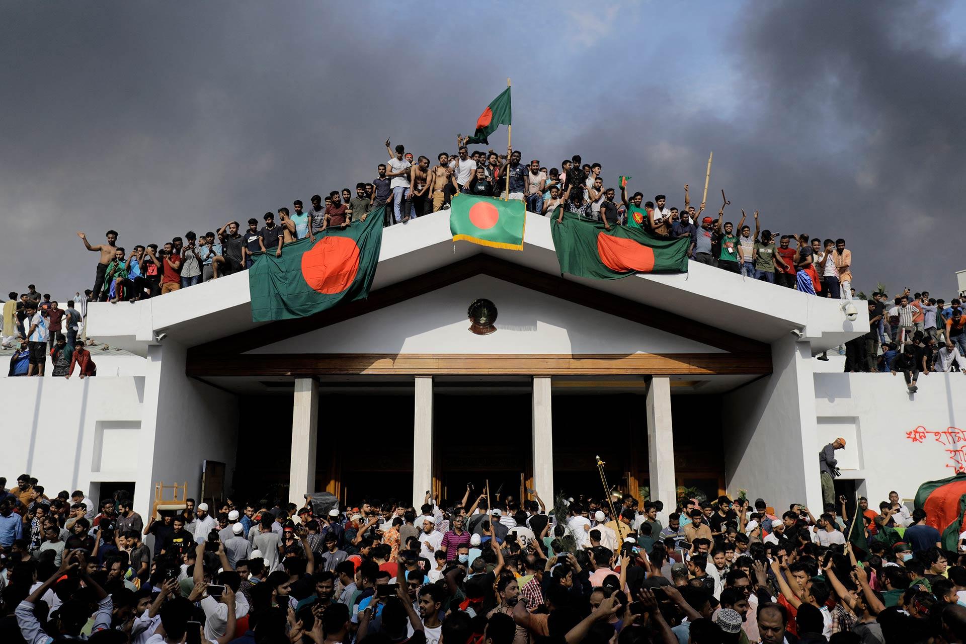 Manifestantes con banderas de Bangladesh irrumpen en el palacio de la primera ministra Sheikh Hasina en la capital Daca