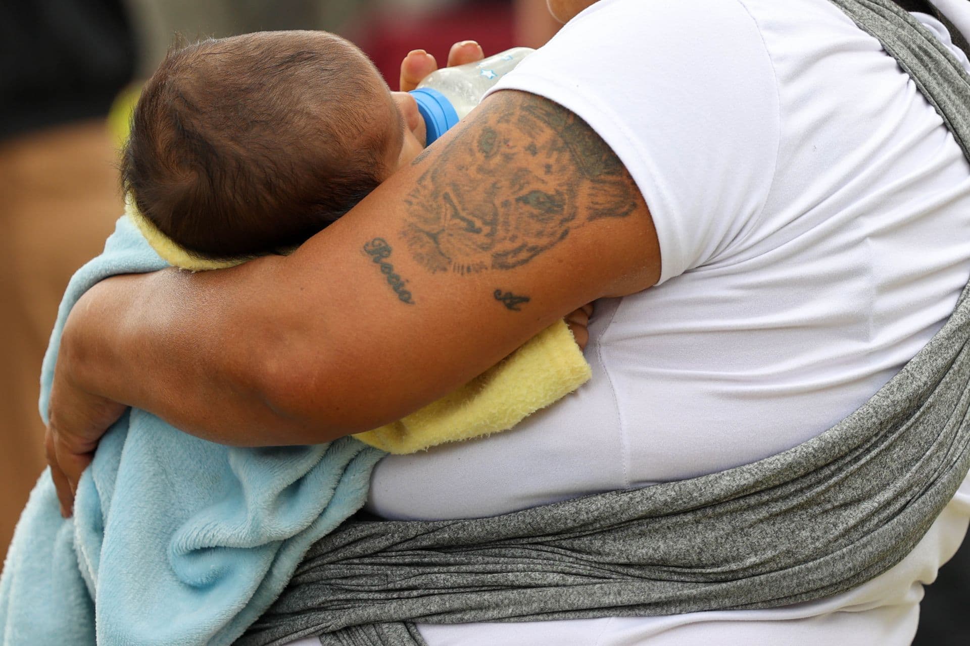 Bebé es sostenido en brazos por sus padres