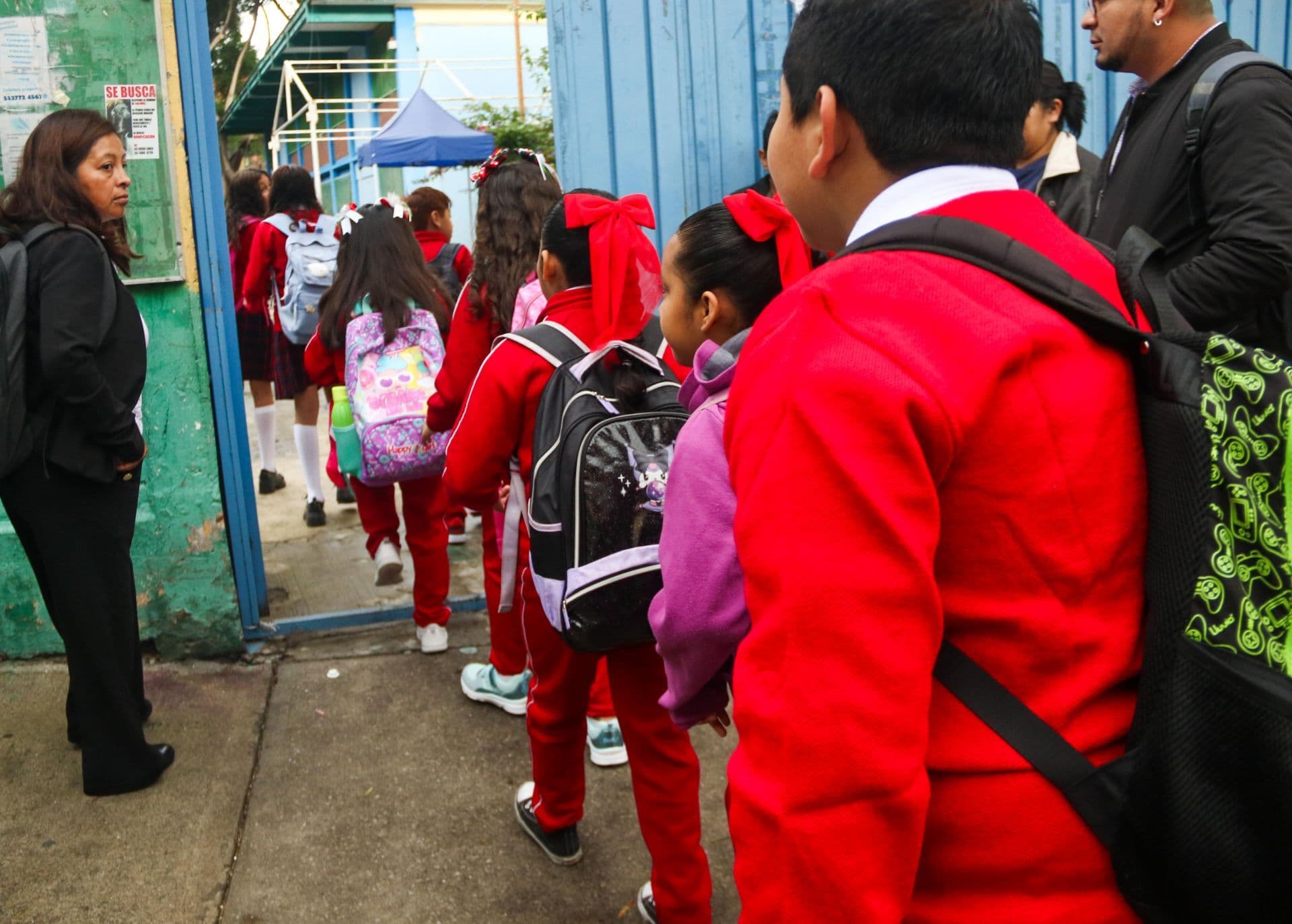 Niños con uniforme ingresan en fila a la escuela