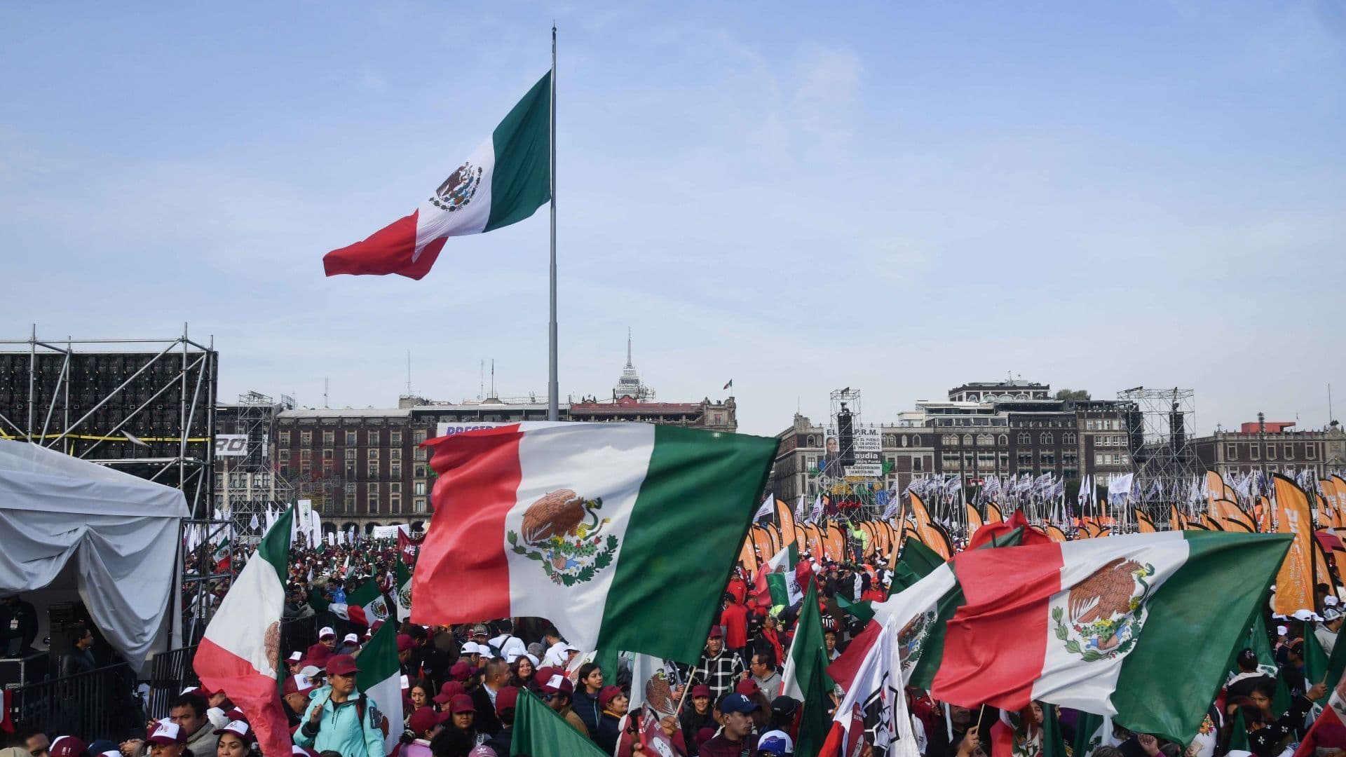 Gente con banderas en el zócalo de cdmx asiste al Zócalo