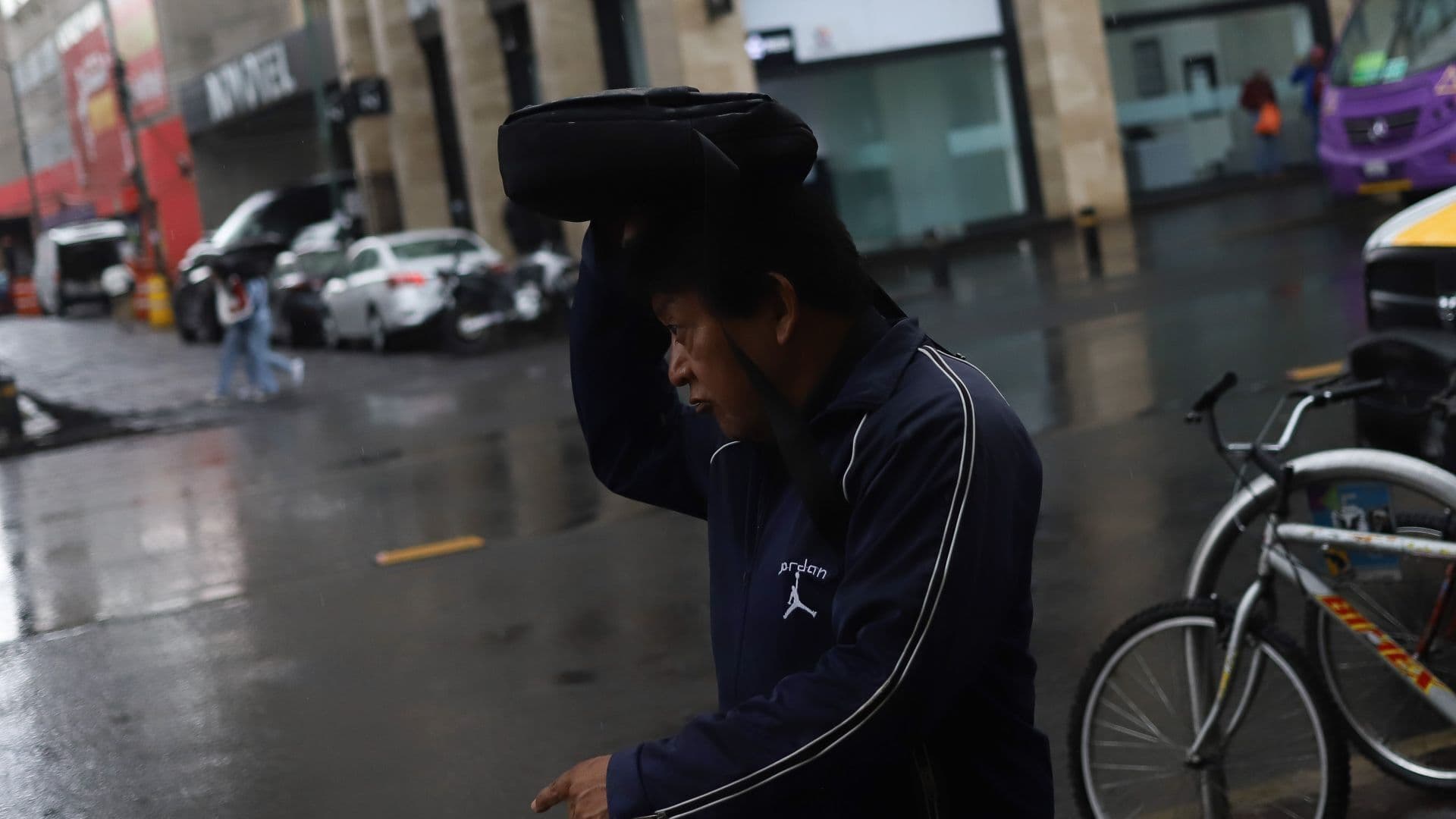 Ciudadano camina en la CDMX bajo la lluvia