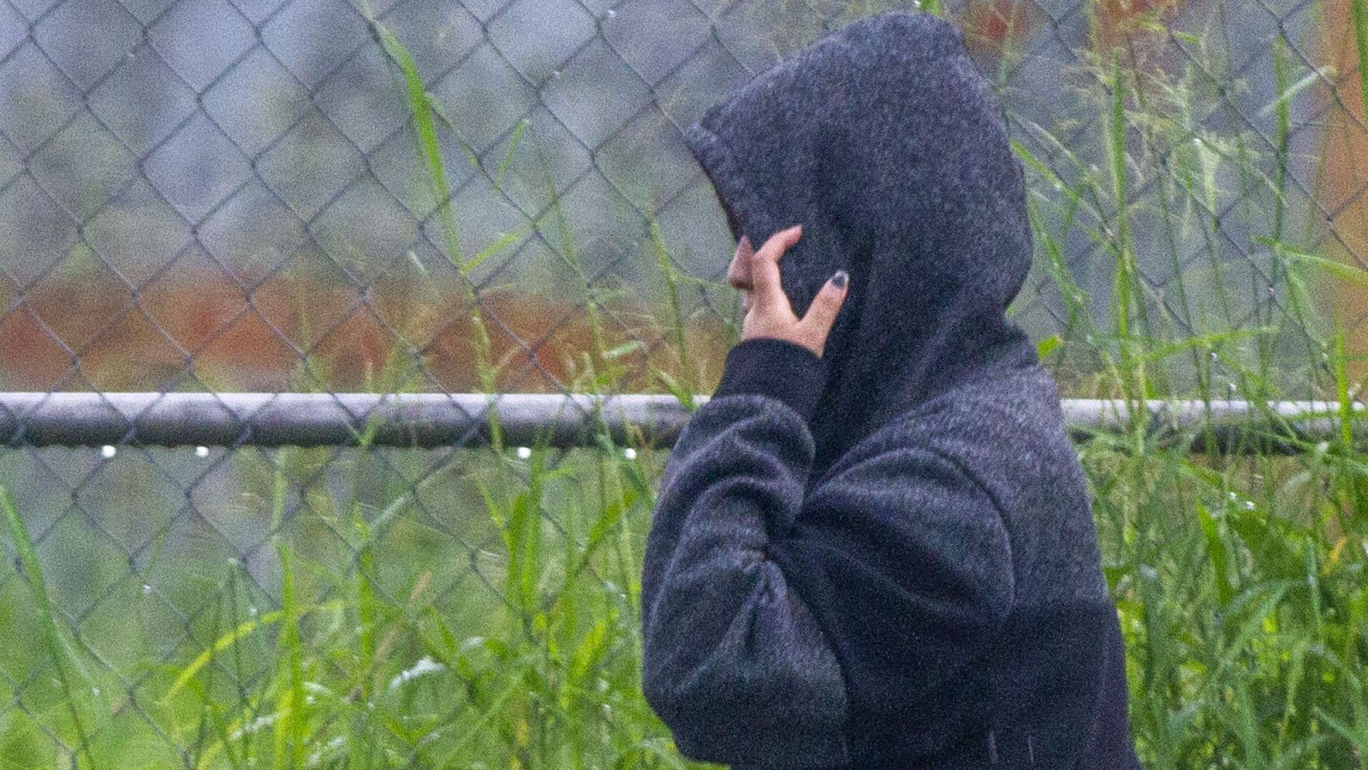 Una mujer se abriga para protegerse de la lluvia