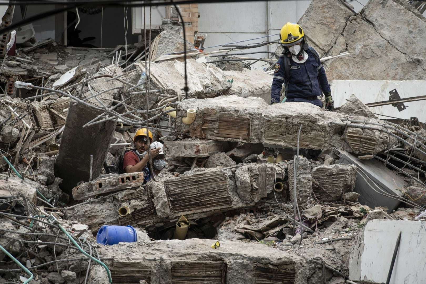Voluntarios, bomberos de Cali y Topos de Tlatelolco realizan labores de rescate en un edificio derrumbado.