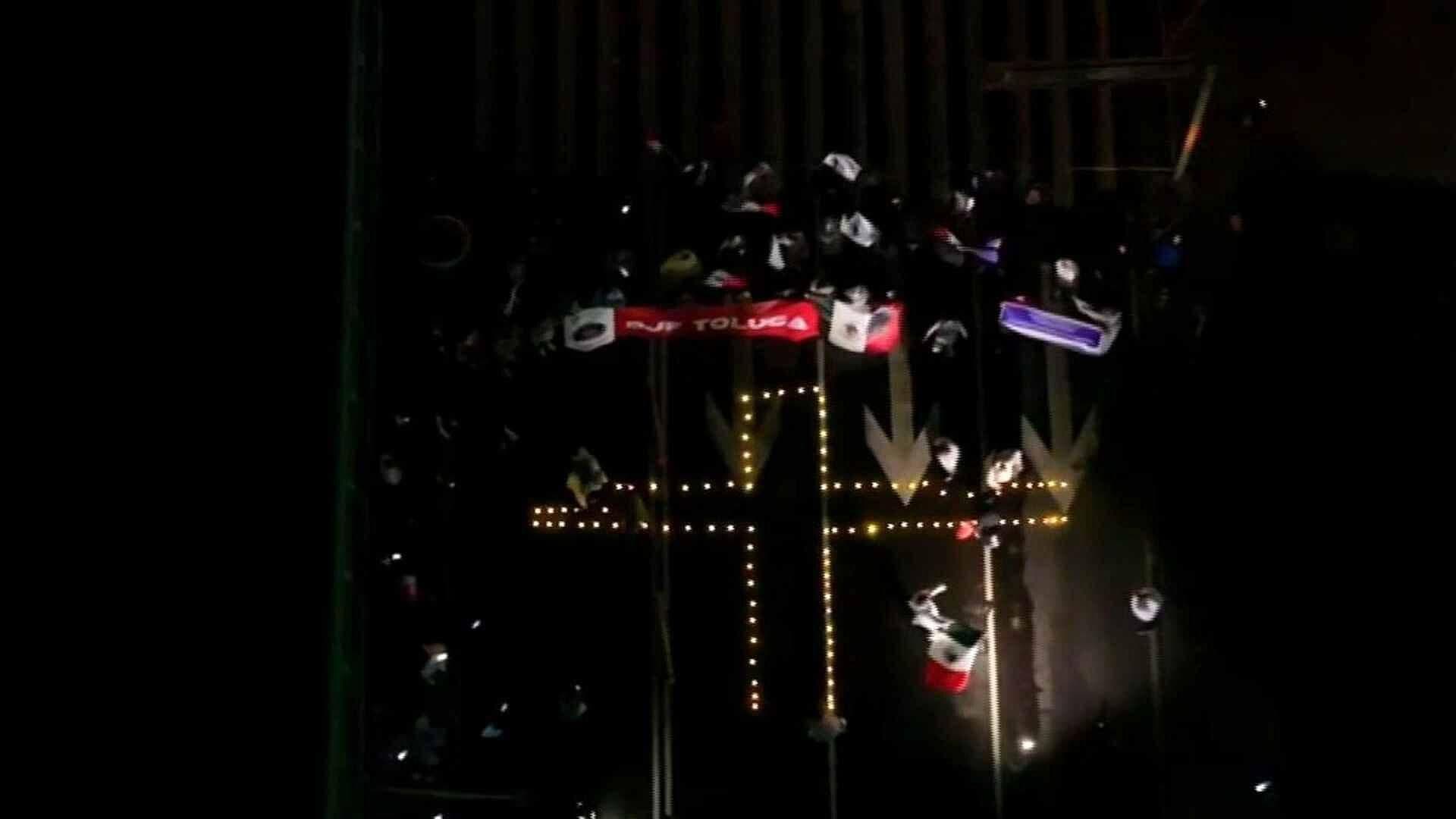 VIDEO: Manifestantes Forman Cruz con Veladoras a las Afueras de la Magdalena Mixhuca