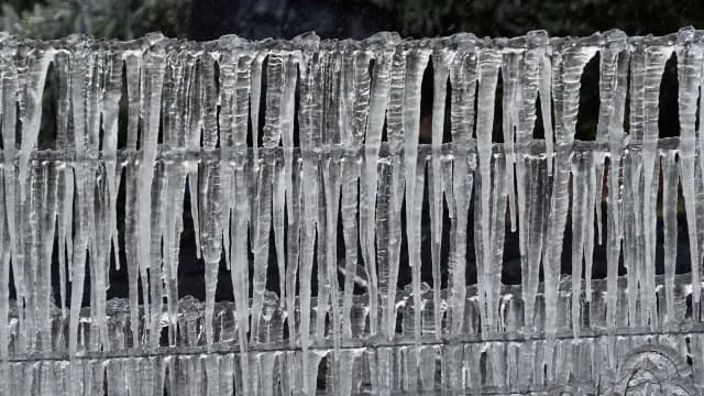 Trozos de hielo cuelgan de una cerca.
