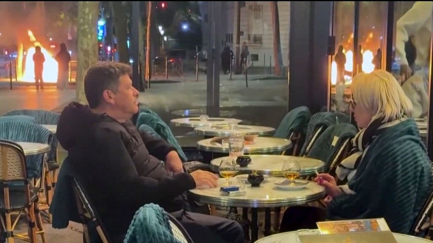Video | Captan a Pareja Cenando Tranquilamente Mientras Hay Incendios Durante Protestas en París