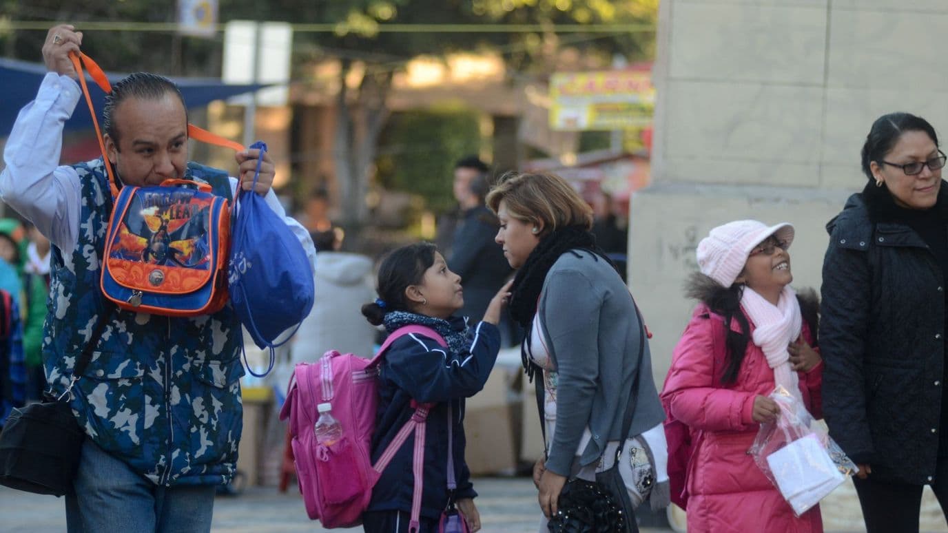 Mamá e hija se despiden, abrigadas, al ingresar a las clases