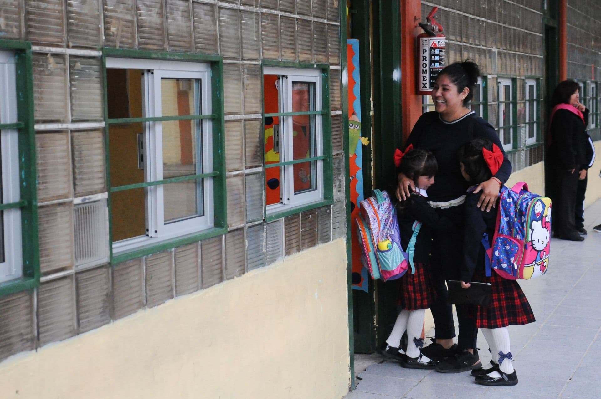 Una madre acompaña a sus dos hijas al salón de clases. Foto: Cuartoscuro