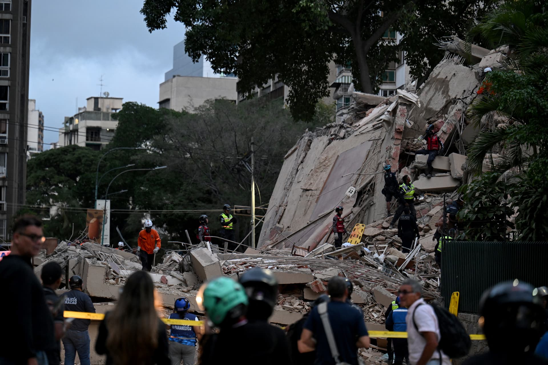 Los rescatistas buscan víctimas entre los escombros de un edificio derrumbado tras el terremoto que sacudió Caracas el 24 de junio de 2026. Un sismo de magnitud 7.1 sacudió Venezuela el miércoles, según informó el Servicio Geológico de Estados Unidos (USGS), provocando pánico en Caracas, de acuerdo con periodistas de AFP.