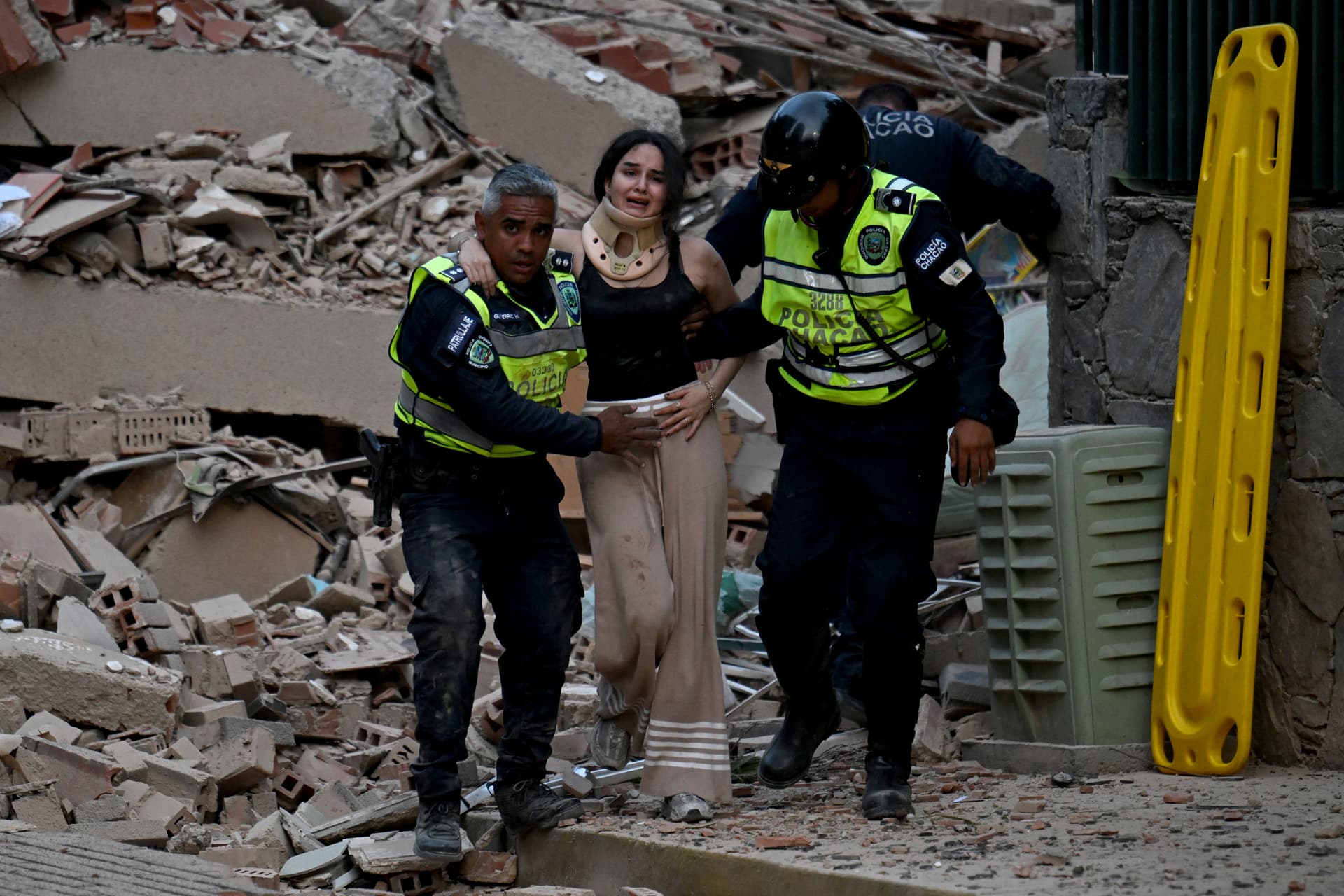 Agentes de la policía municipal evacuan a una víctima herida de un edificio derrumbado tras un terremoto en Caracas el 24 de junio de 2026. Foto: AFP