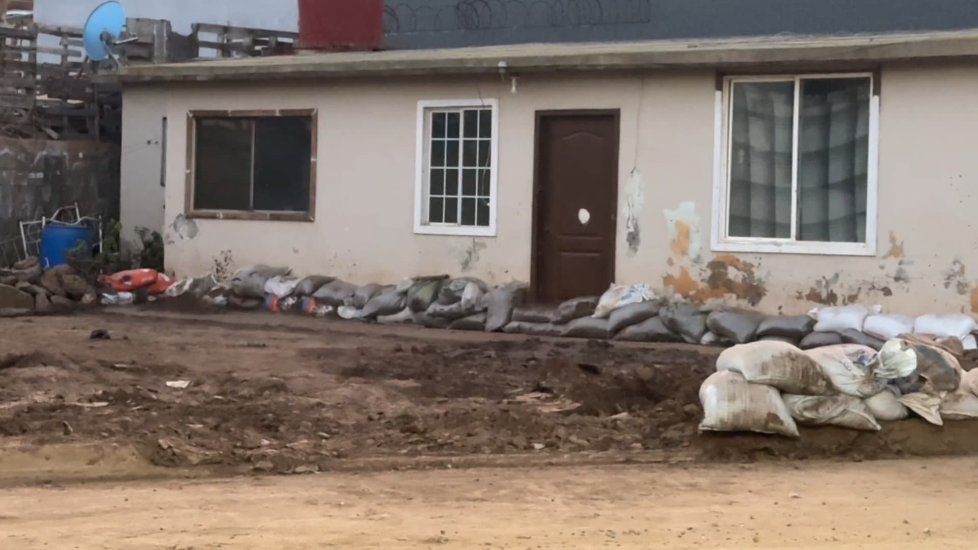 Sacos de arena colocados de forma improvisada en la entrada de una vivienda para frenar el agua