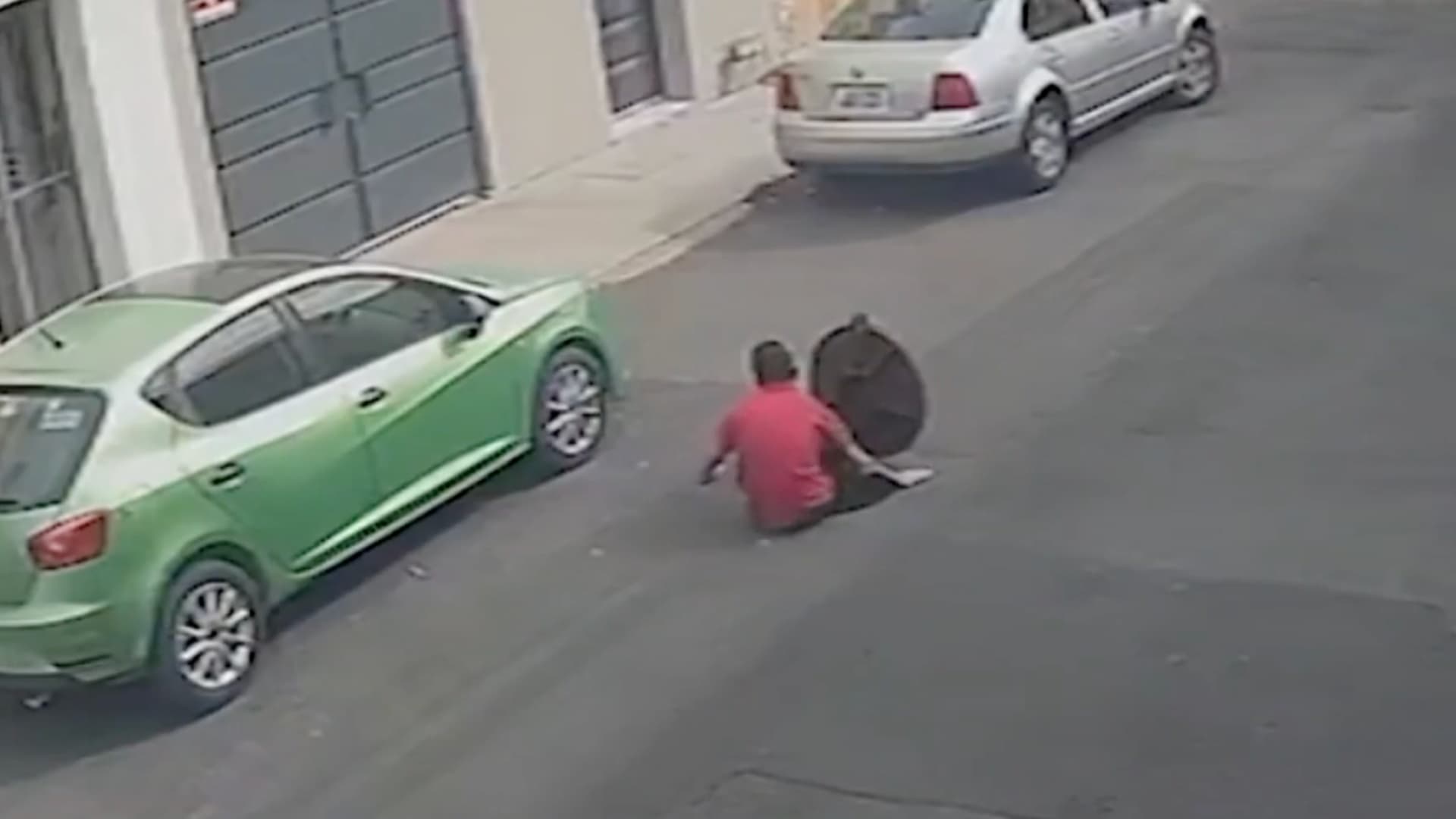 Persona saliendo de coladera en Guadalajara, Jalisco.