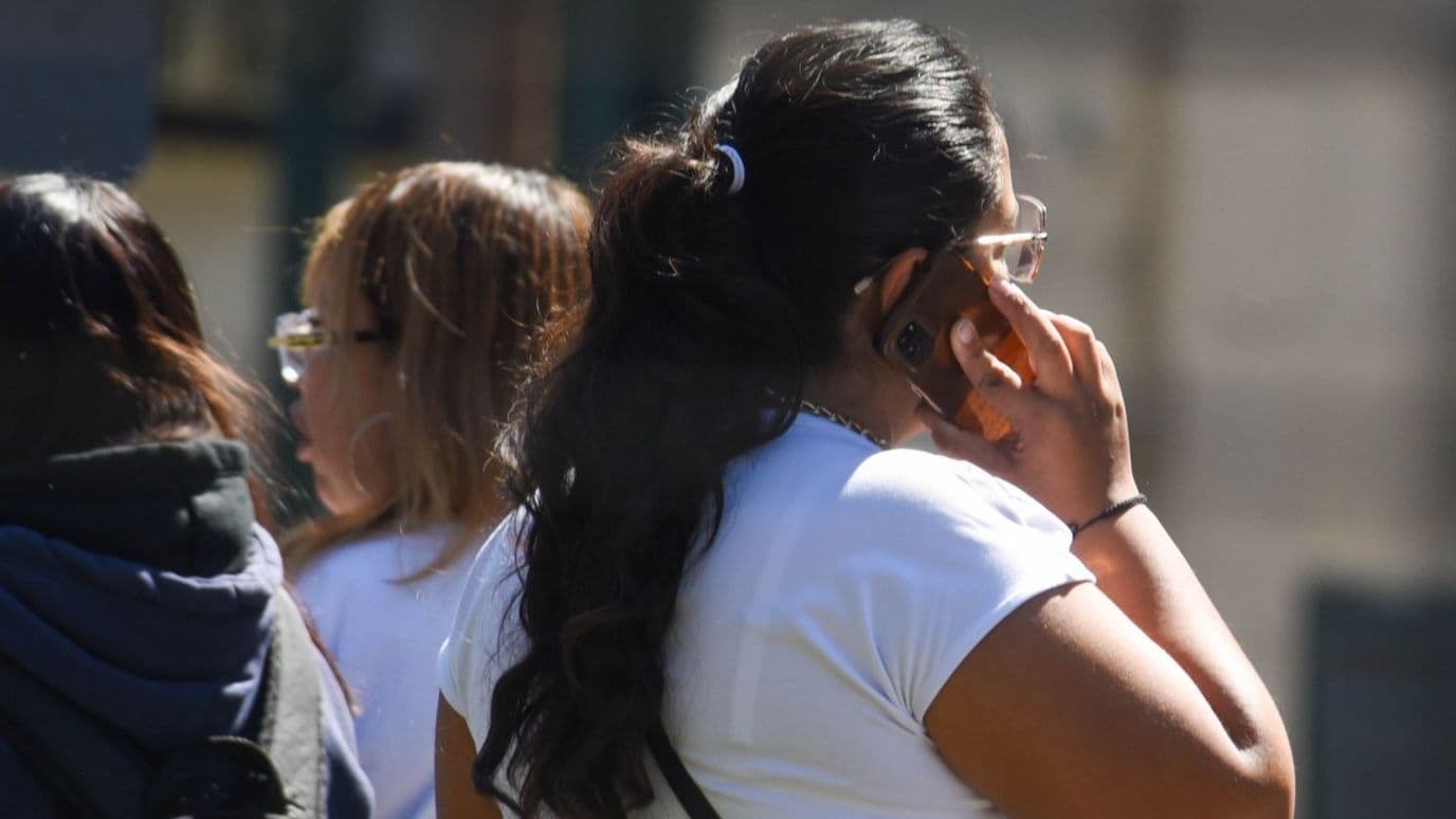 Persona habla por celular. Como Evitar ser víctima de la estafa por buzón de voz.