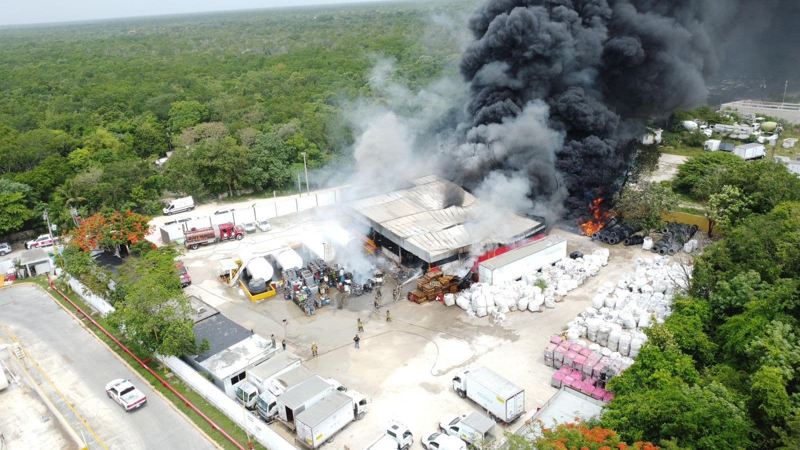 Bomberos atienden fuerte incendio en almacén de aceites en Cancún.