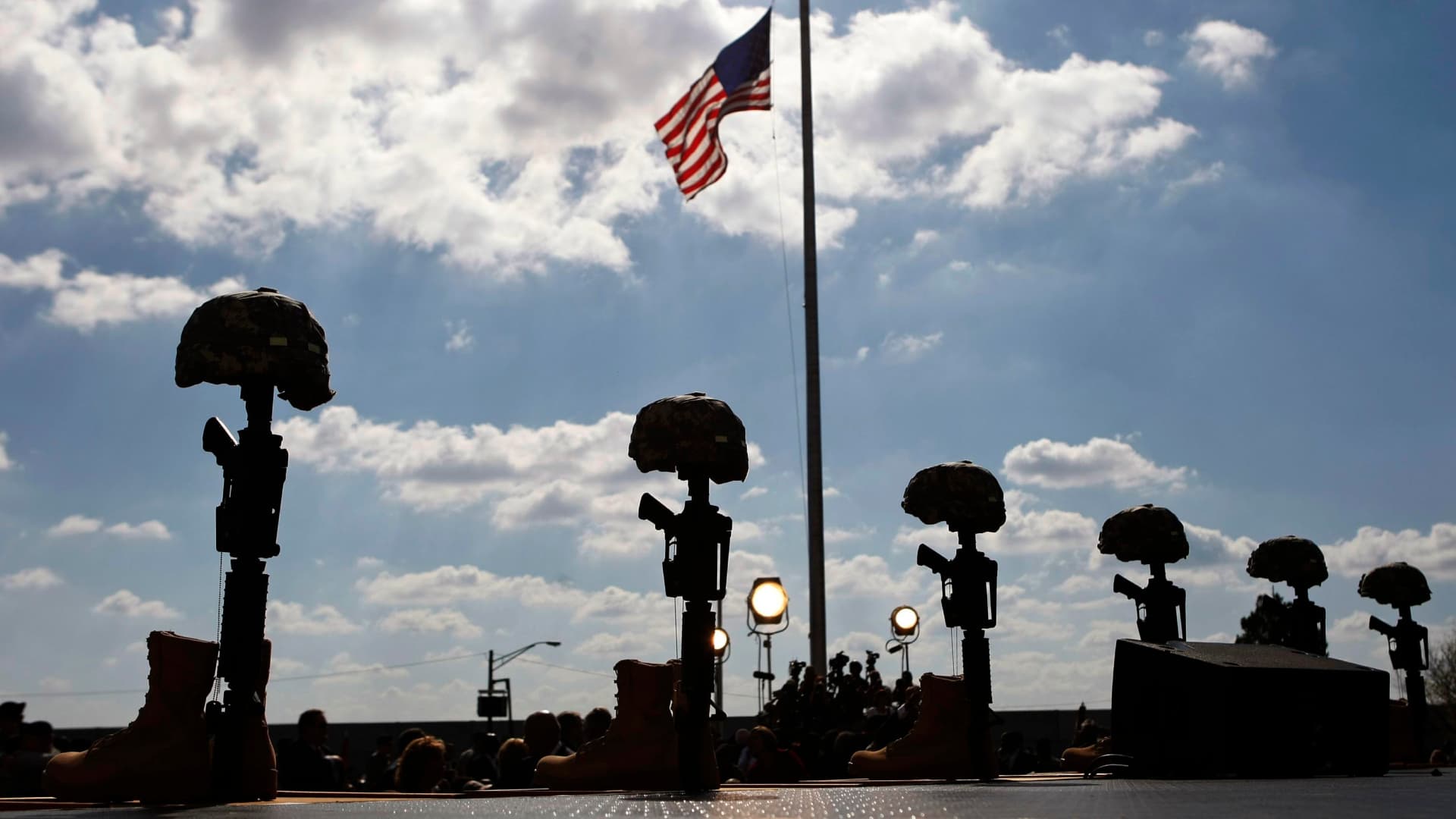 Memorial de rifles, botas y cascos, junto a una bandera de EUA, en Fort Hood, Texas