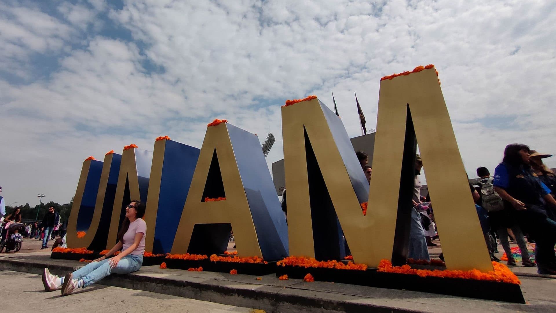 Mujer se retrata frente a tipografías de la UNAM. Resultados pase Reglamentado UNAM 2026.