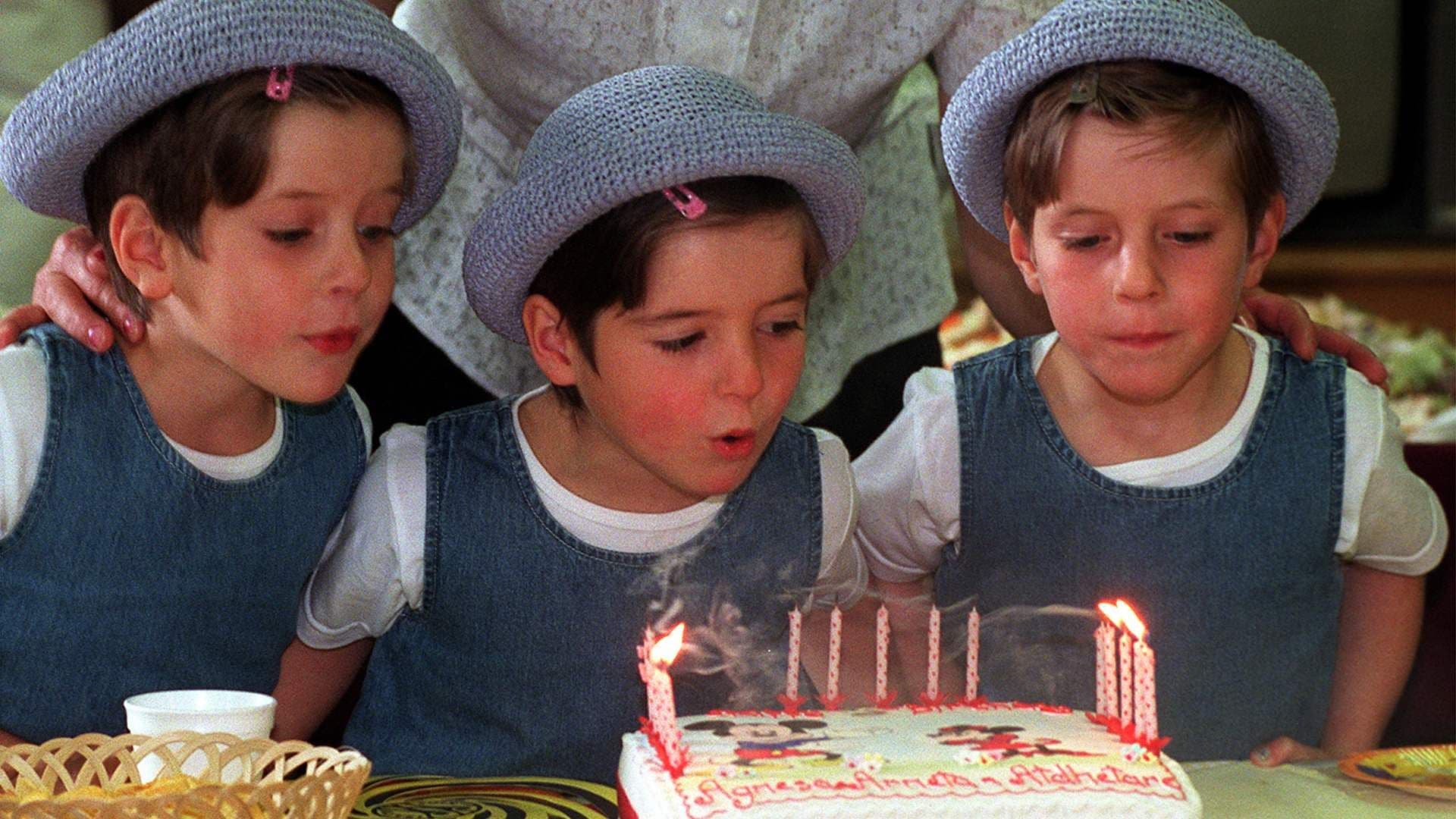 Niños apagan velas de pastel. Qué tan común es tu cumpleaños.