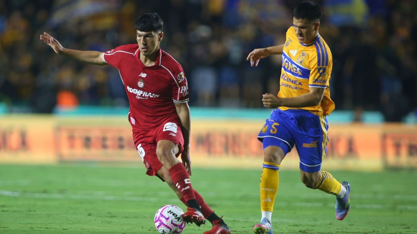 Jugadores de Toluca y Tigres disputan un balón.