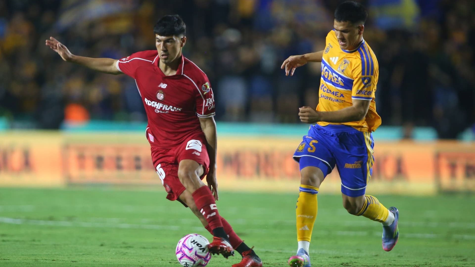 Jugadores de Toluca y Tigres disputan un balón.