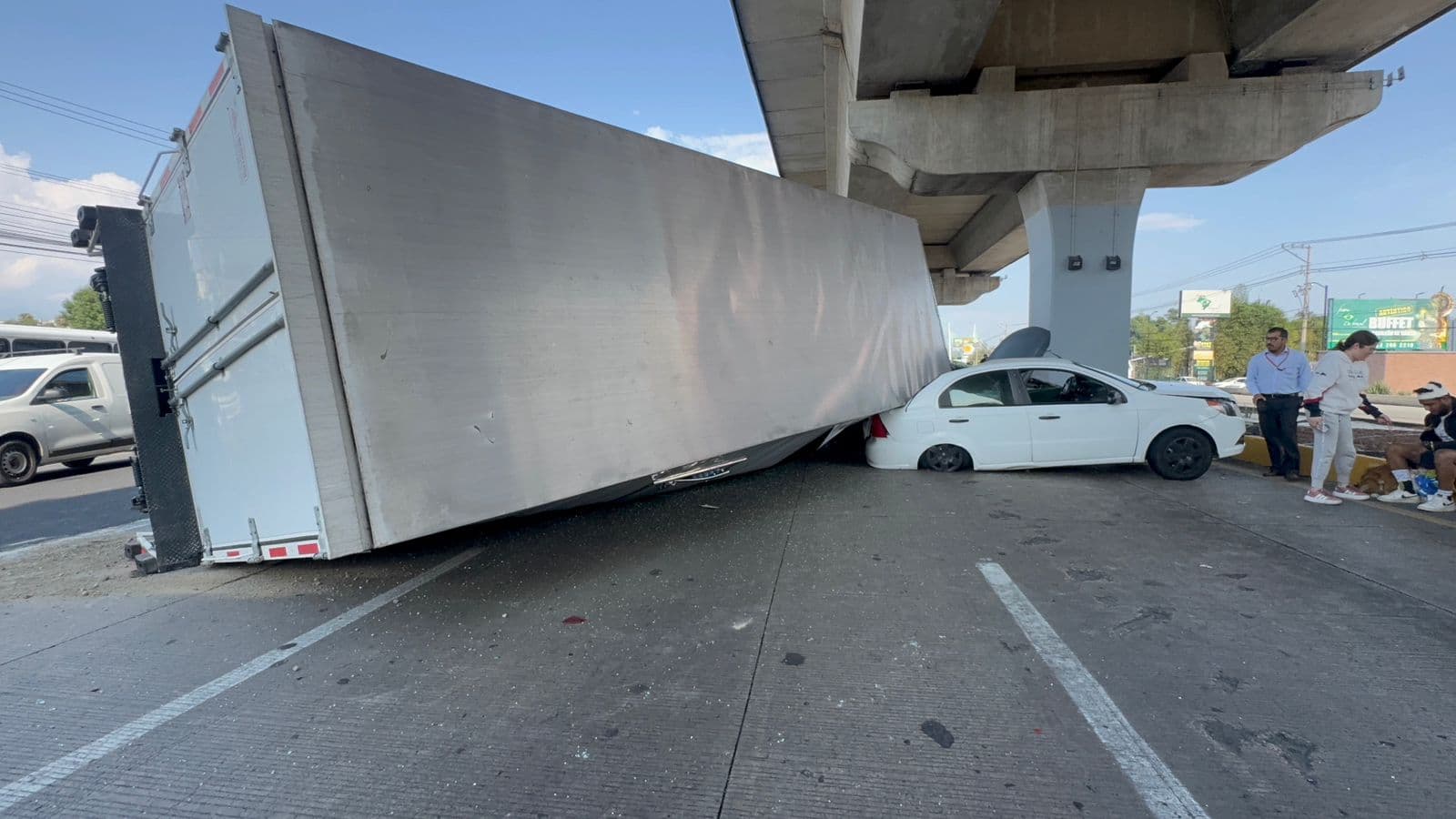 El tractocamió cayó sobre dos automóviles en la autopista.
