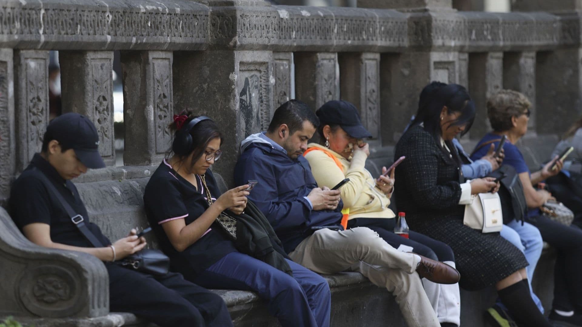 Personas utilizando teléfono móvil