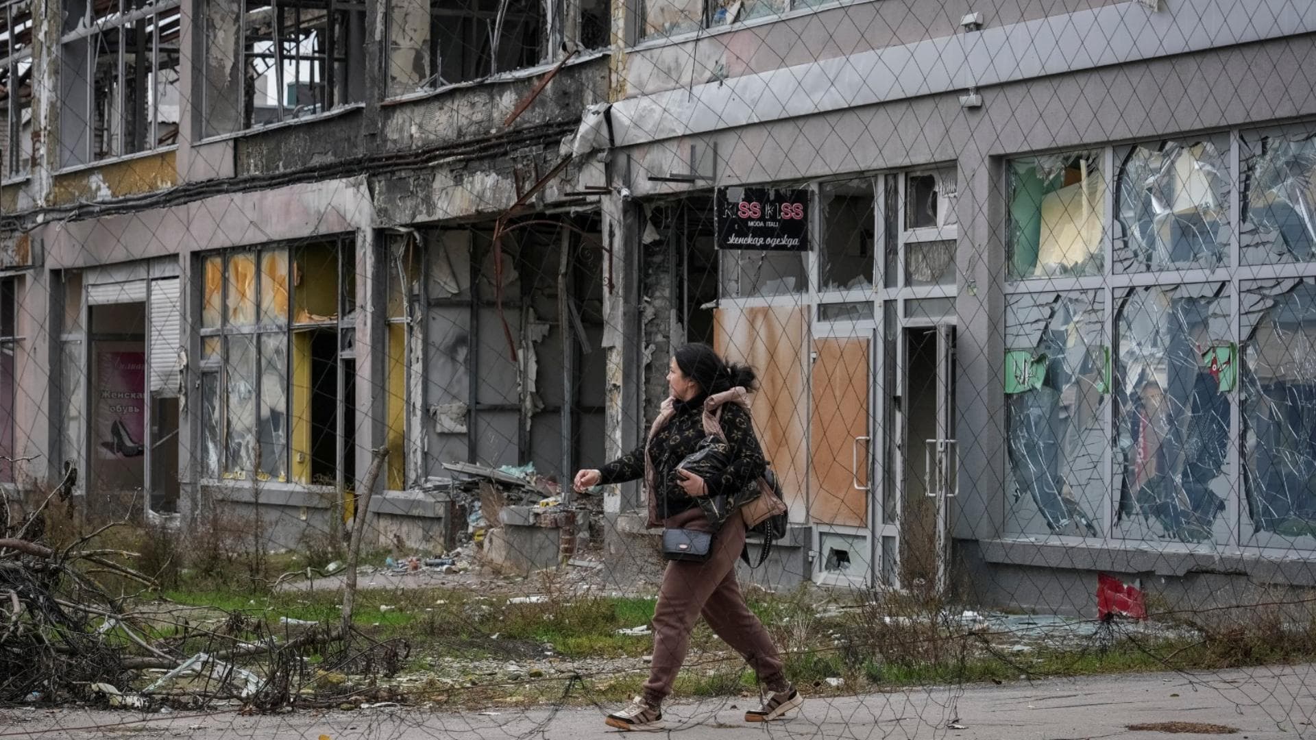 Una mujer camina por una calle cubierta con una red antidrones, en medio del ataque de Rusia contra Ucrania, en Jersón, el 27 de octubre de 2026. Foto: Reuters