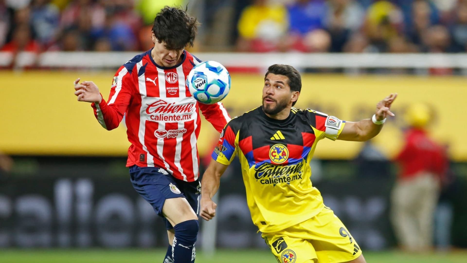 Diego Campillo y Henry Martin disputan la pelota en una edición del Clásico Nacional entre Chivas y América.