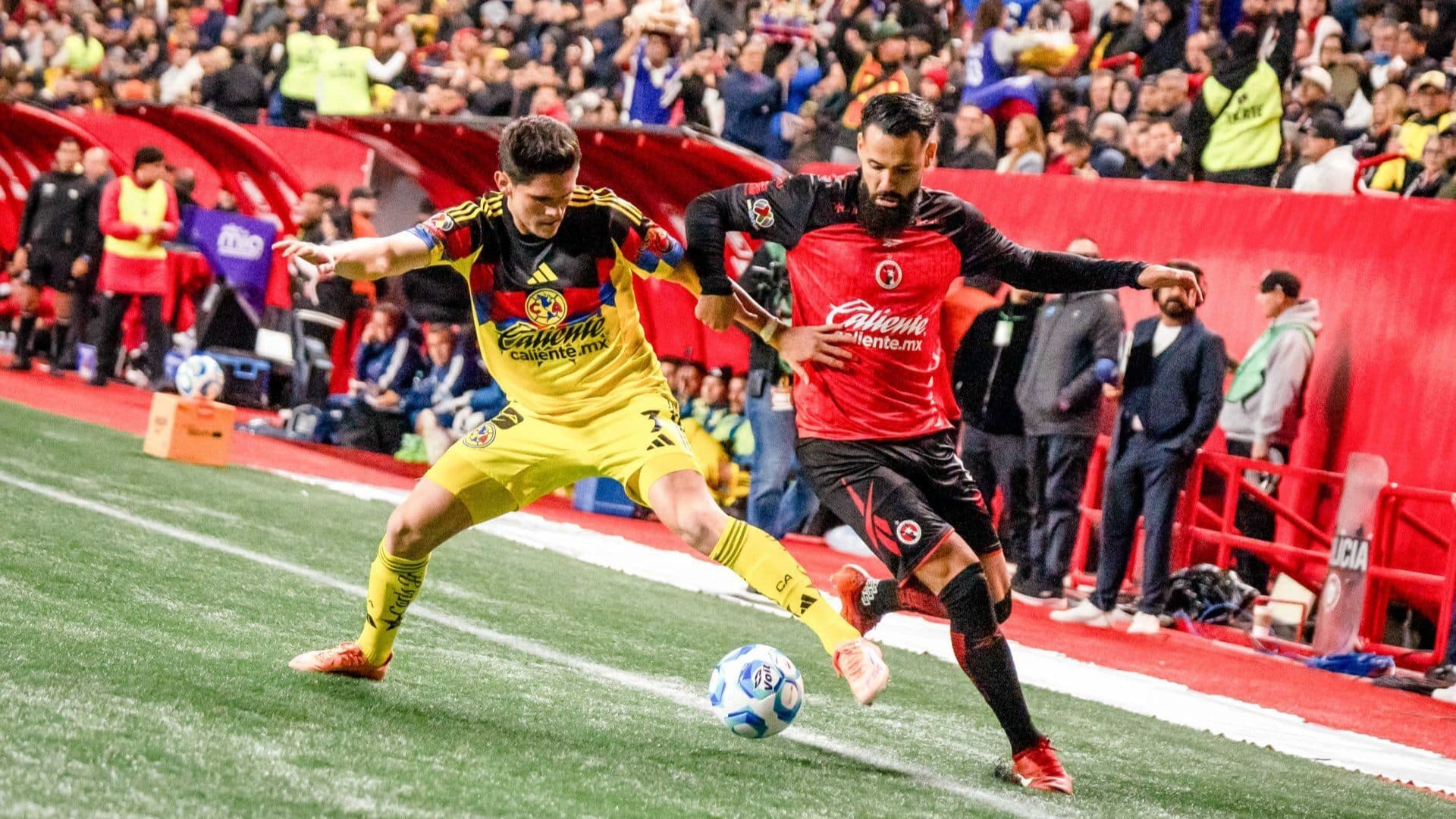 Mourad El Ghezouani, jugador de los Xolos, en plena batalla con el americanista Israel Reyes.