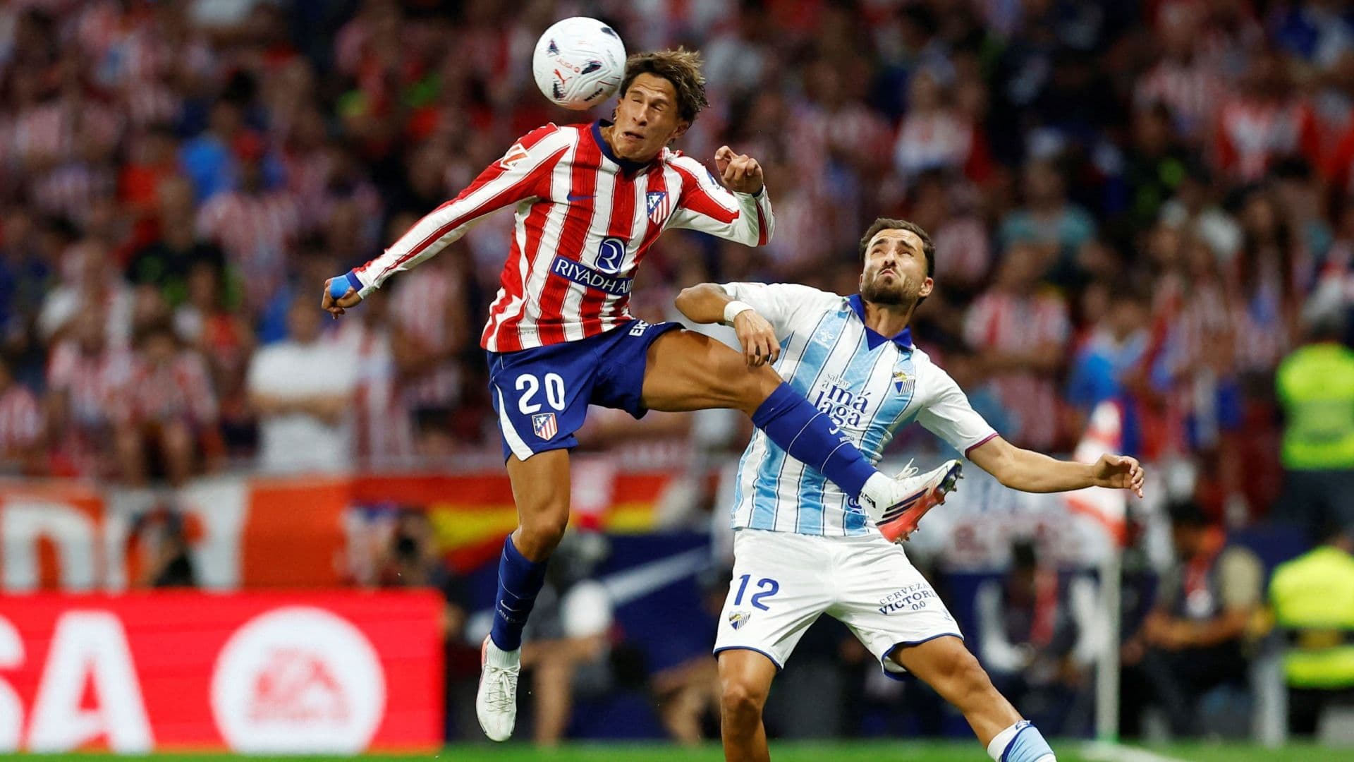 Giuliano Simeone cabecea la pelota ante José Salinas en el partido del Atlético de Madrid contra el Málaga.