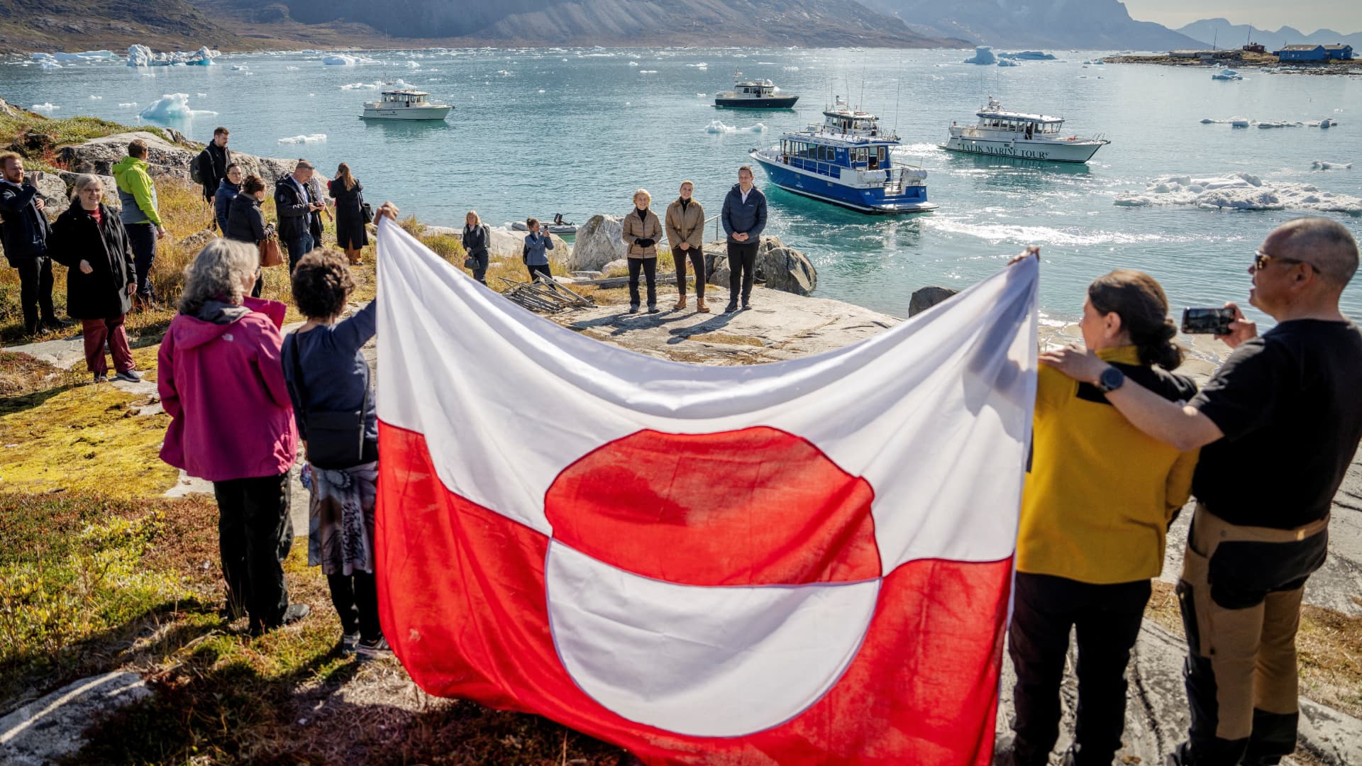 Ciudadanos sostienen la bandera de Groenlandia durante la visita de funcionarios europeos