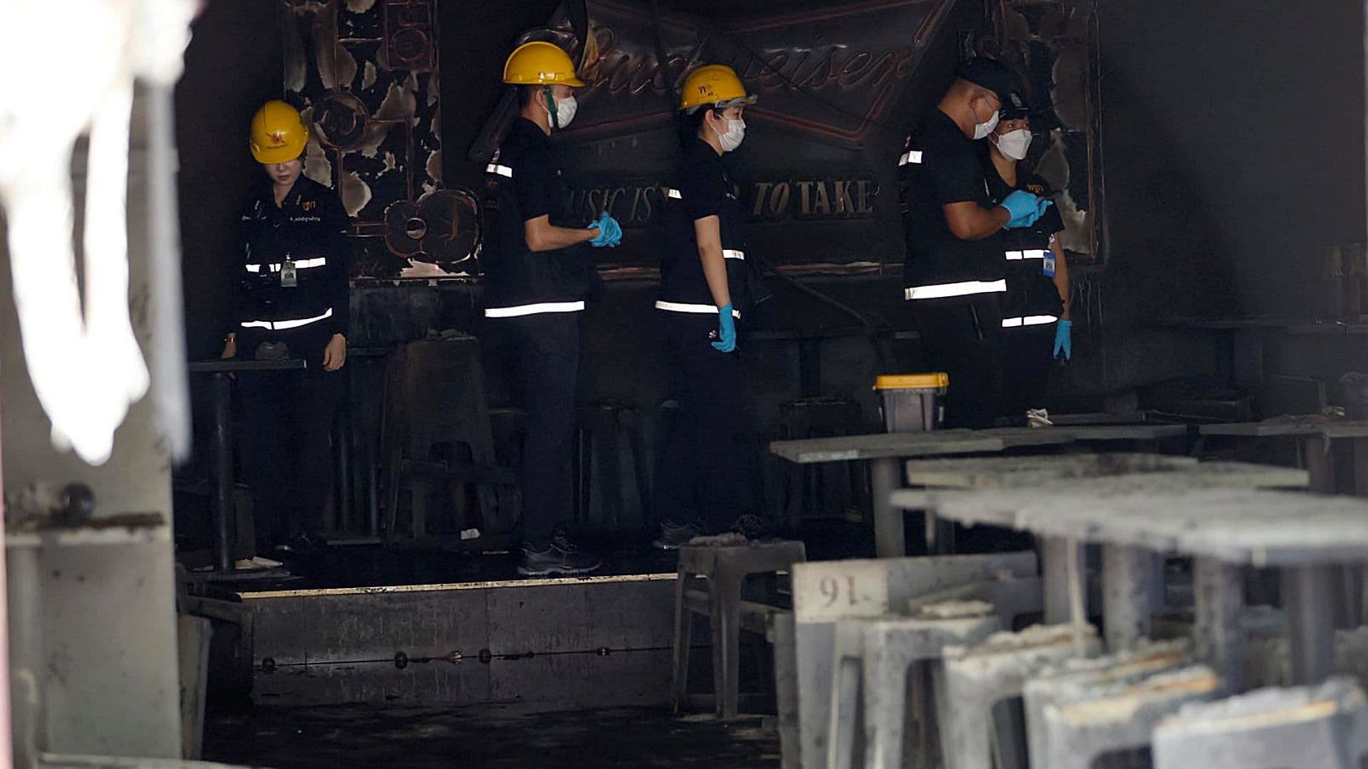 Agentes de la policía forense tailandesa examinan el lugar de un incendio en un bar de Bangkok. Foto: EFE