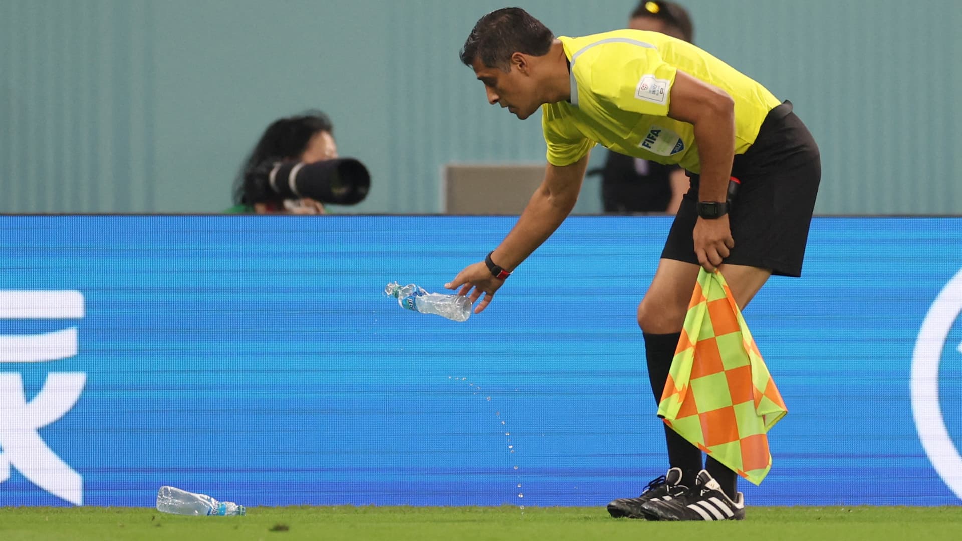 Un abanderado retira botellas de agua lanzadas al campo de futbol