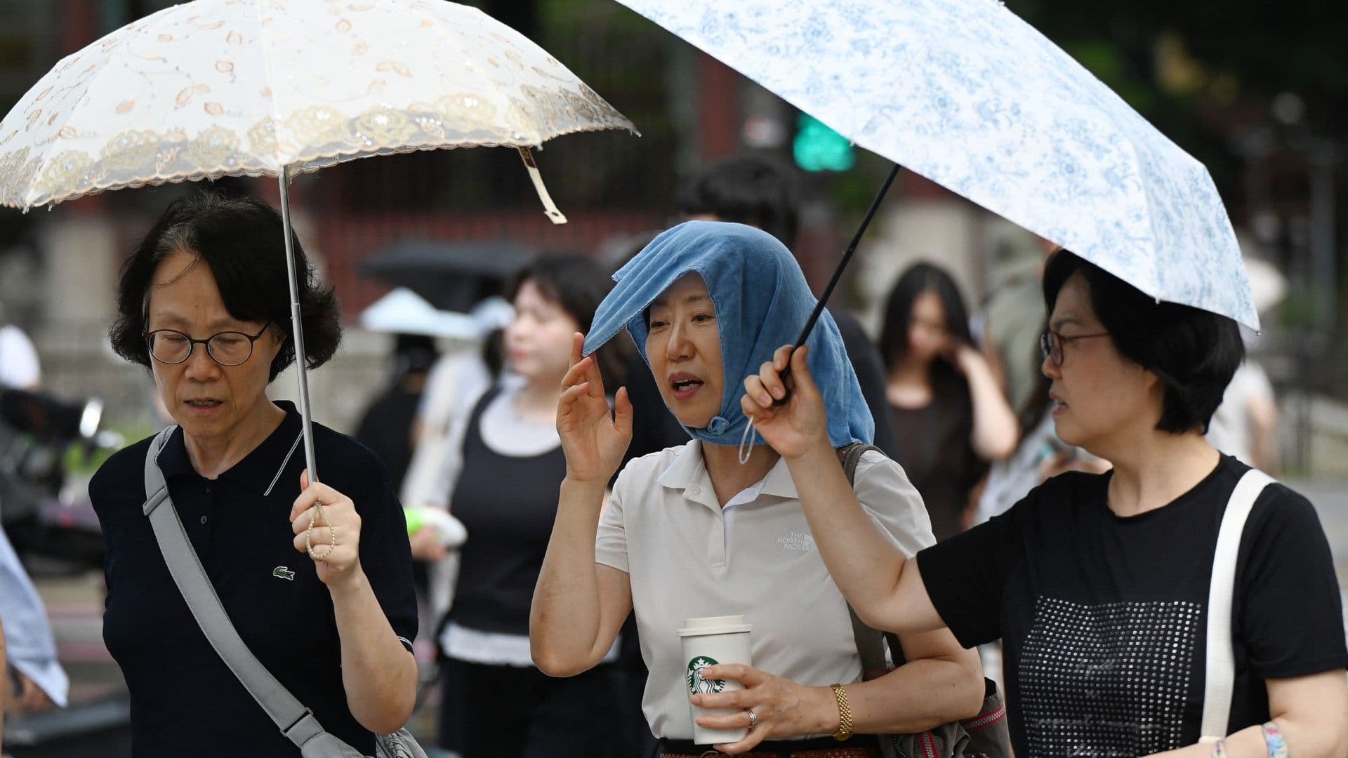 Personas se cubren del intenso calor en Corea del Sur