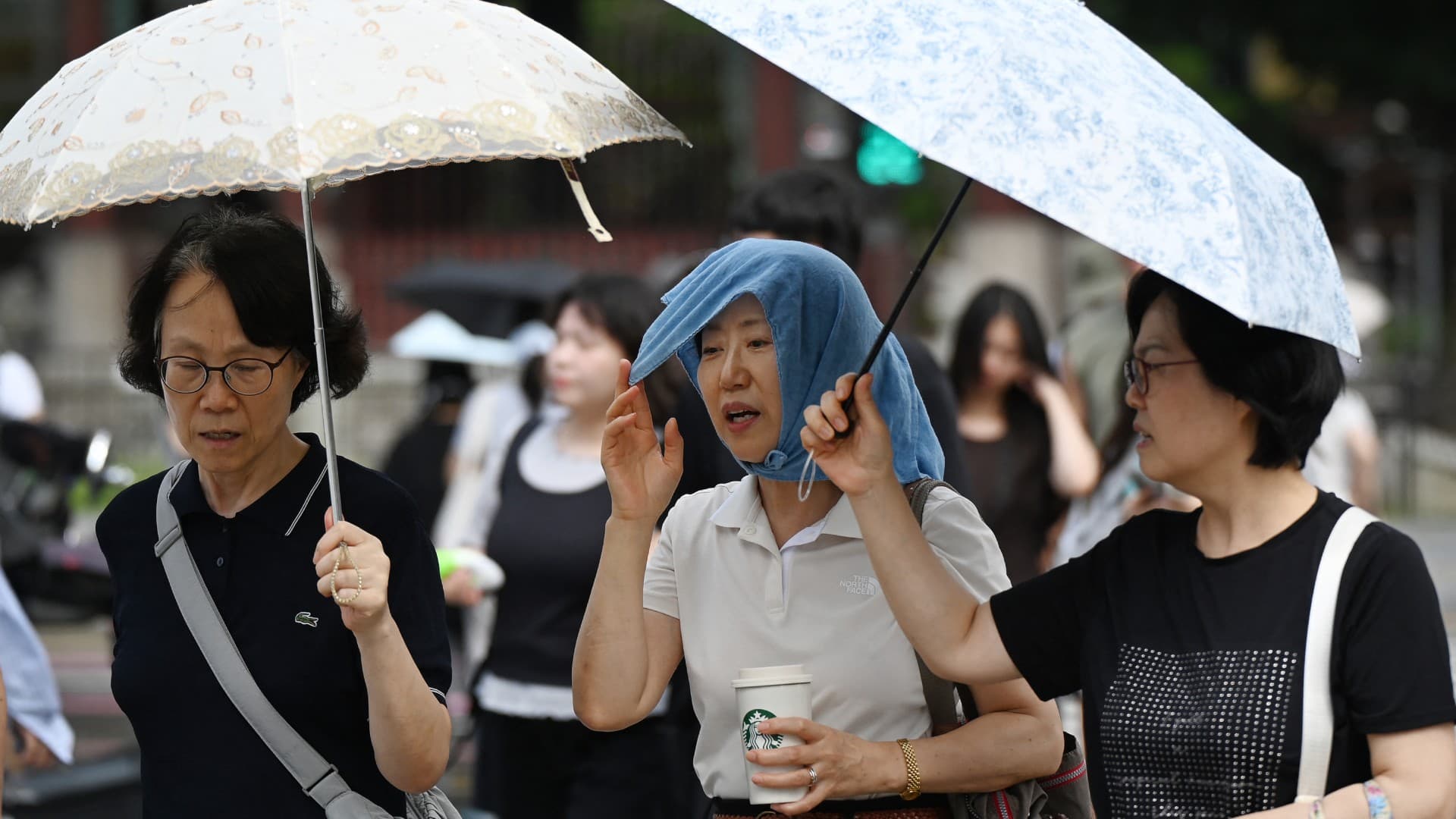 Personas se cubren del intenso calor en Corea del Sur