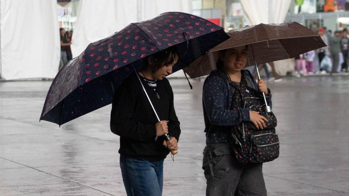 Mujeres se cubren de la lluvia en el Zócalo de la CDMX el 9 de octubre 2026. Foto: Cuartoscuro | Archivo