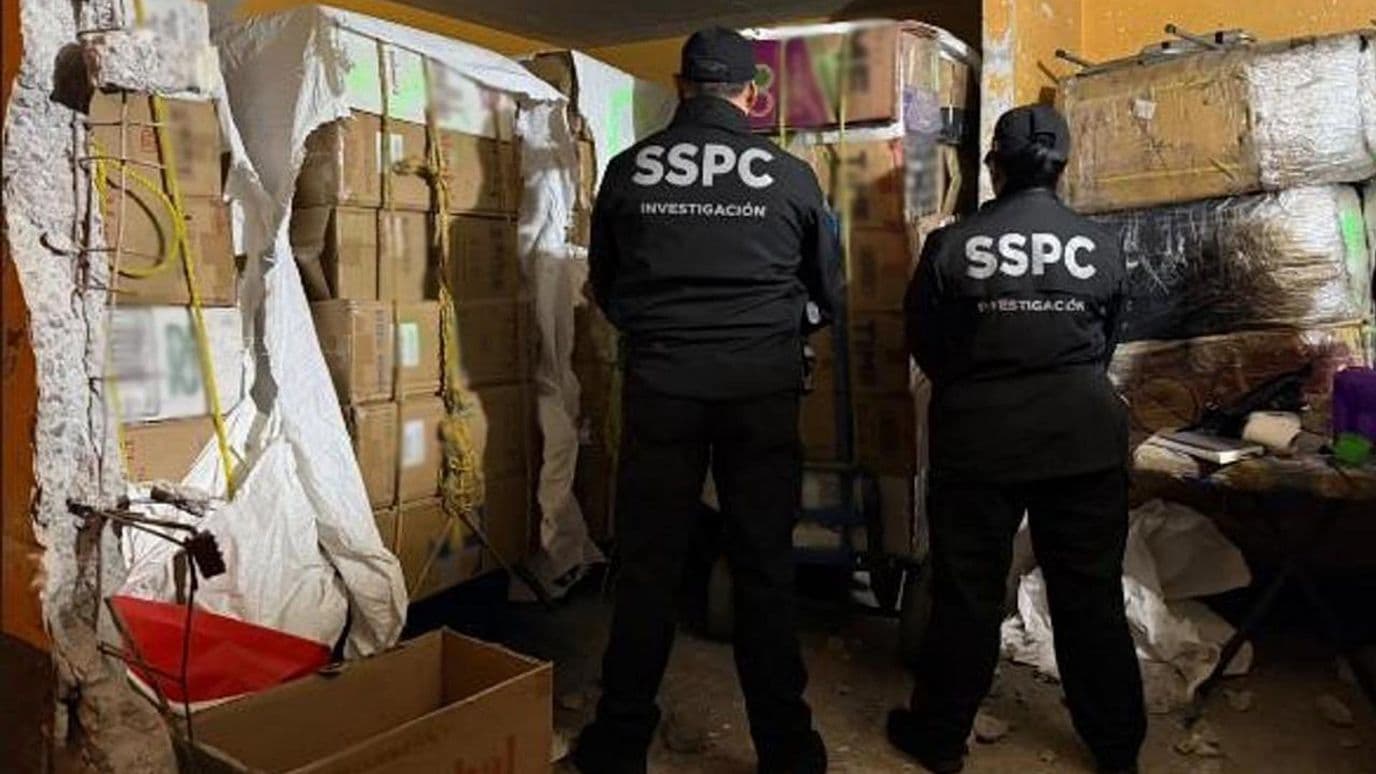Policías de la SSPC custodian las cajas de cigarros apócrifos decomisados en CDMX. Foto: @GabSeguridadMX