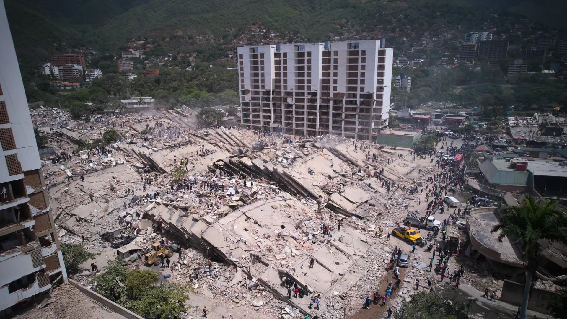 Residentes y rescatistas buscan entre los escombros dos días después de un sismo que remeció La Guaira, Venezuela, el 26 de junio de 2026. (AP Foto/Juan Pablo Arraez)