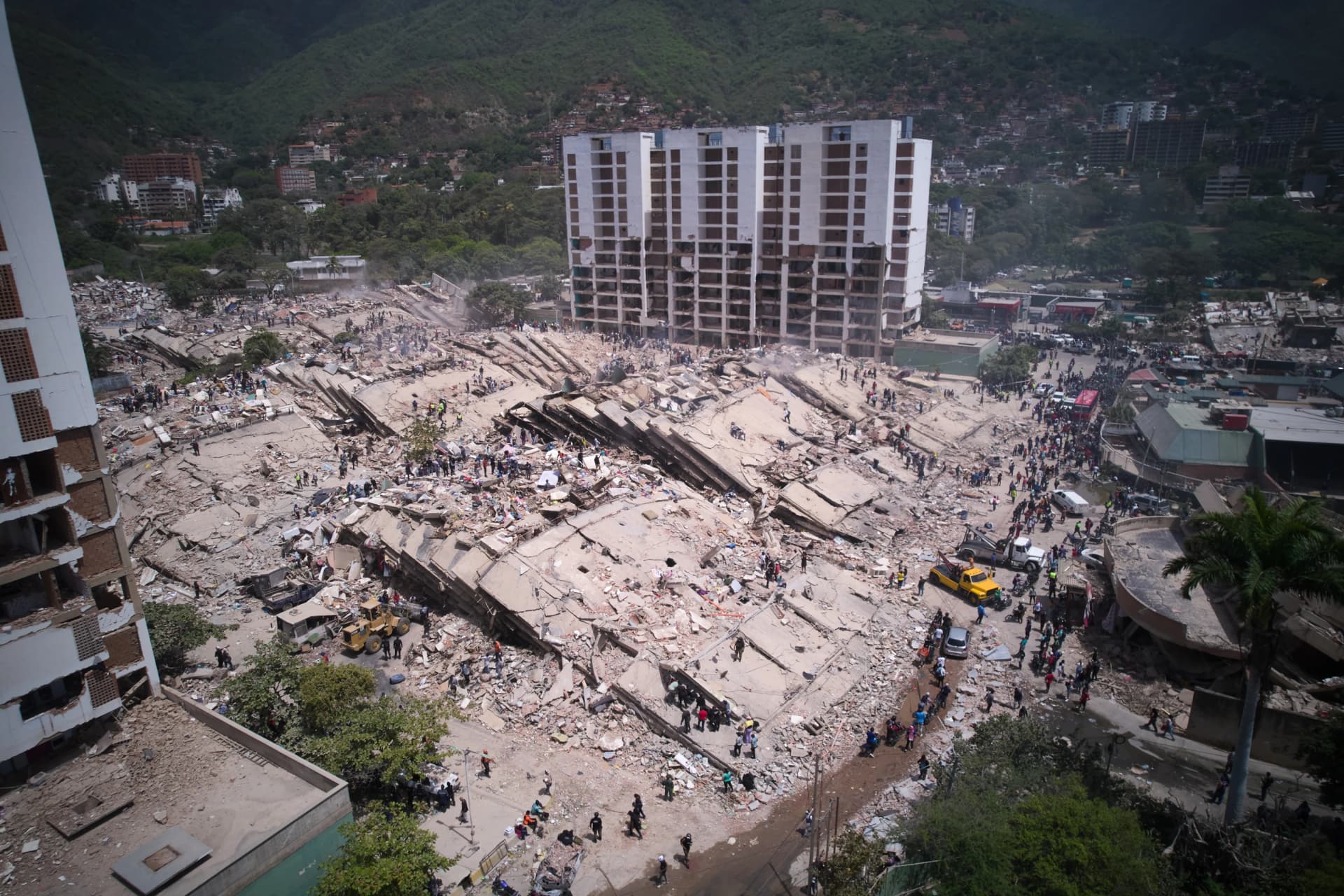 Residentes y rescatistas buscan entre los escombros dos días después de un sismo que remeció La Guaira, Venezuela, el 26 de junio de 2026. (AP Foto/Juan Pablo Arraez)