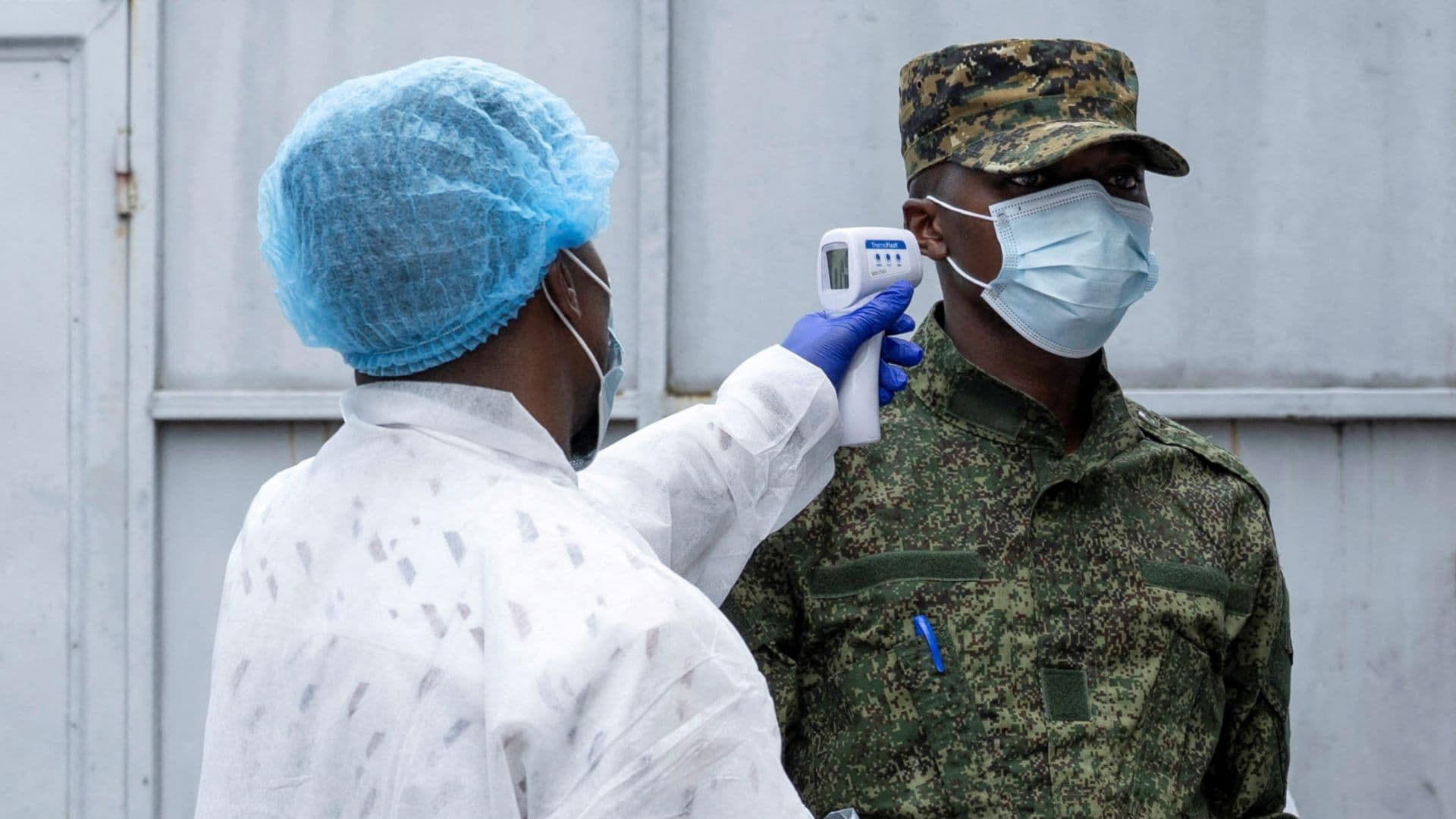 Un trabajador de salud toma la temperatura a una persona.