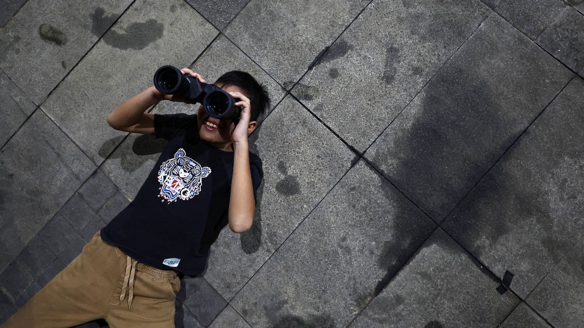 Niño observa un eclipse lunar en Jakarta