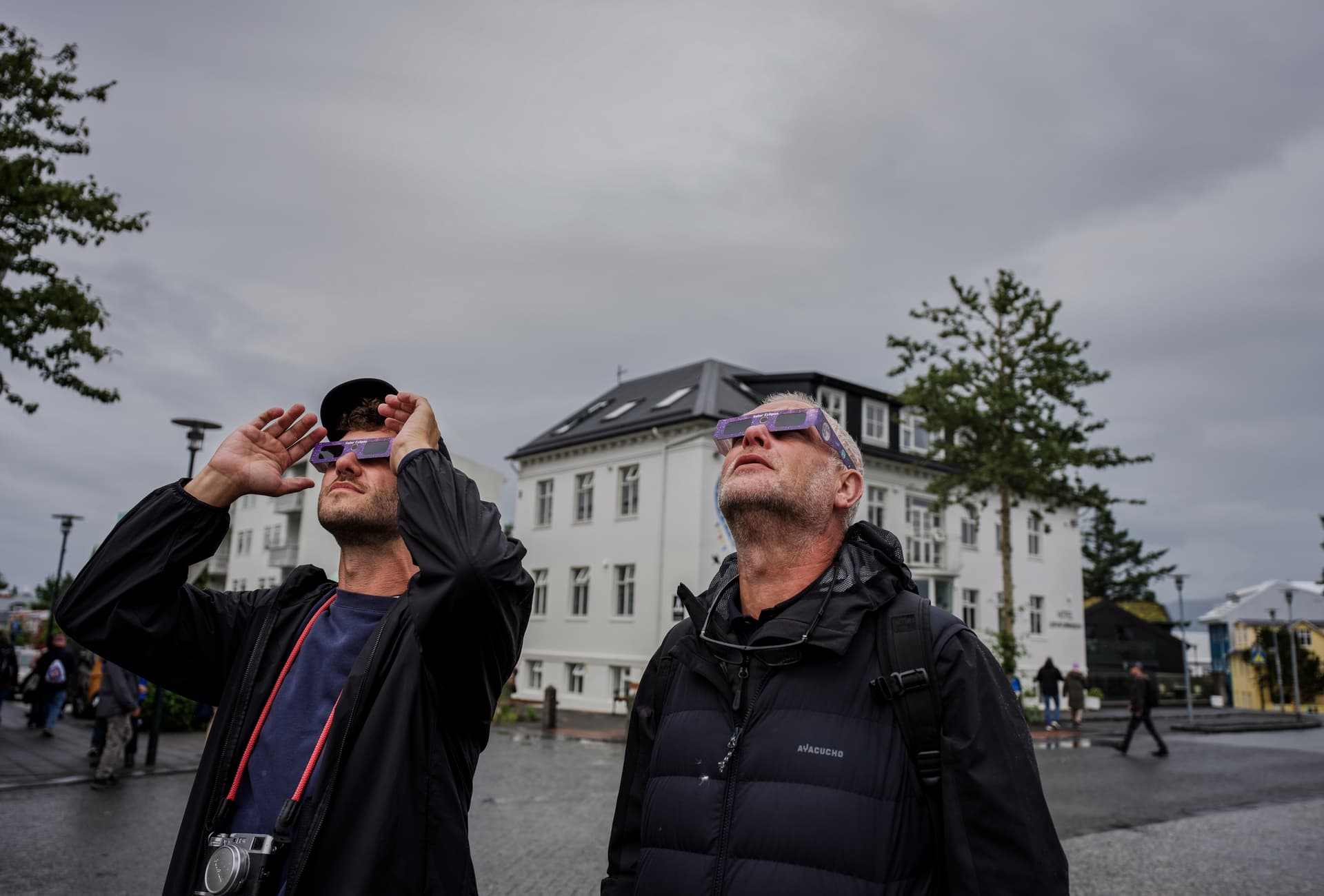 Personas voltean al cielo antes del eclipse solar en Reikiavik, Islandia.