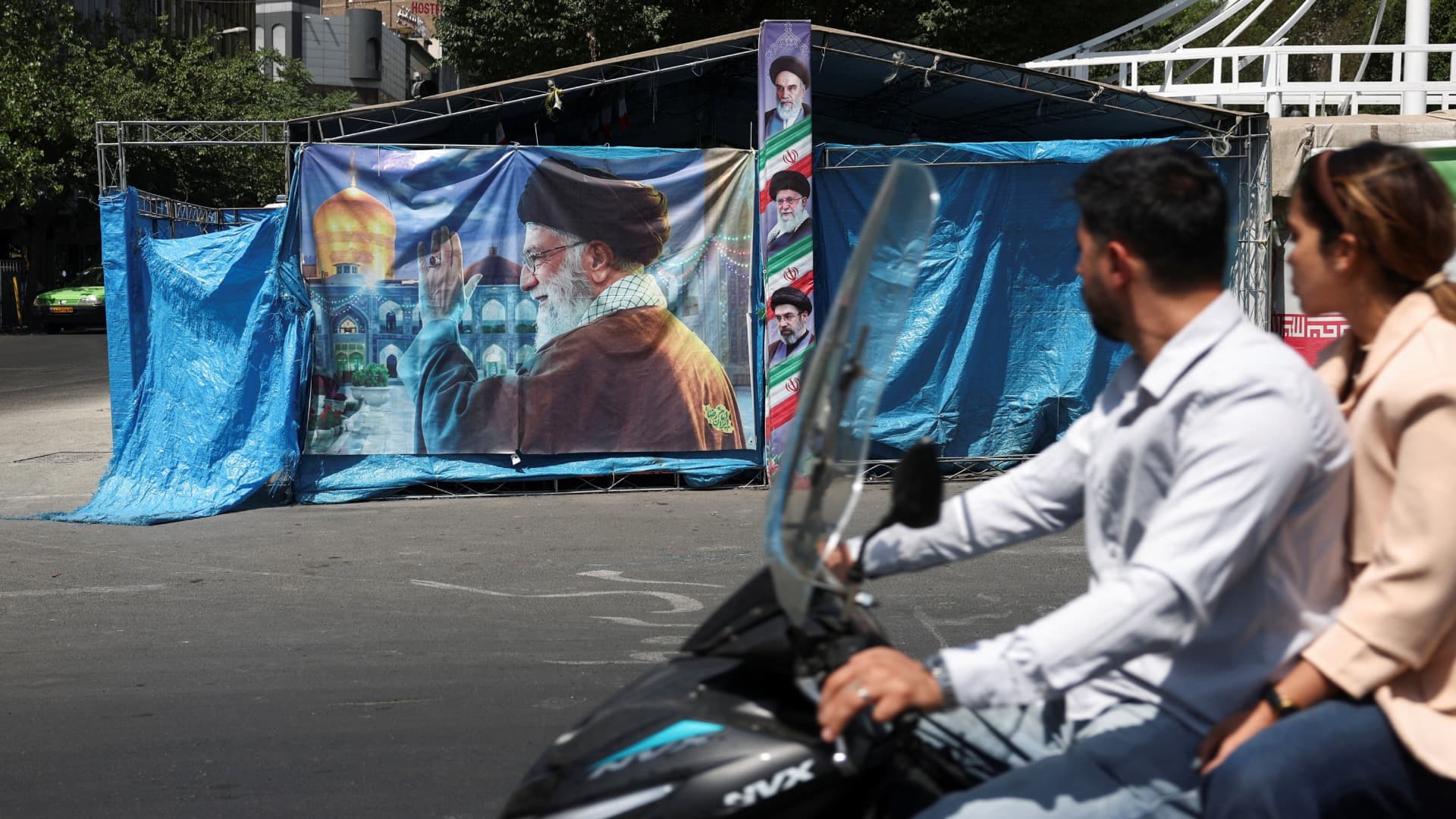 Personas pasan junto a pancarta con foto del difunto líder supremo de Irán, el ayatolá Ali Khamenei, en Teherán.
