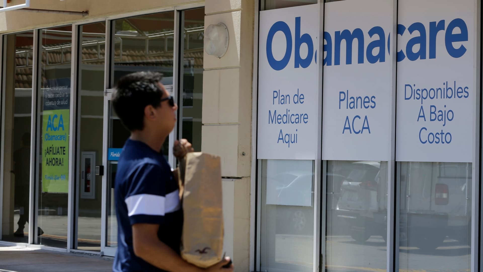 Un hombre pasa frente a una oficina de seguros médicos en Hialeah, Florida