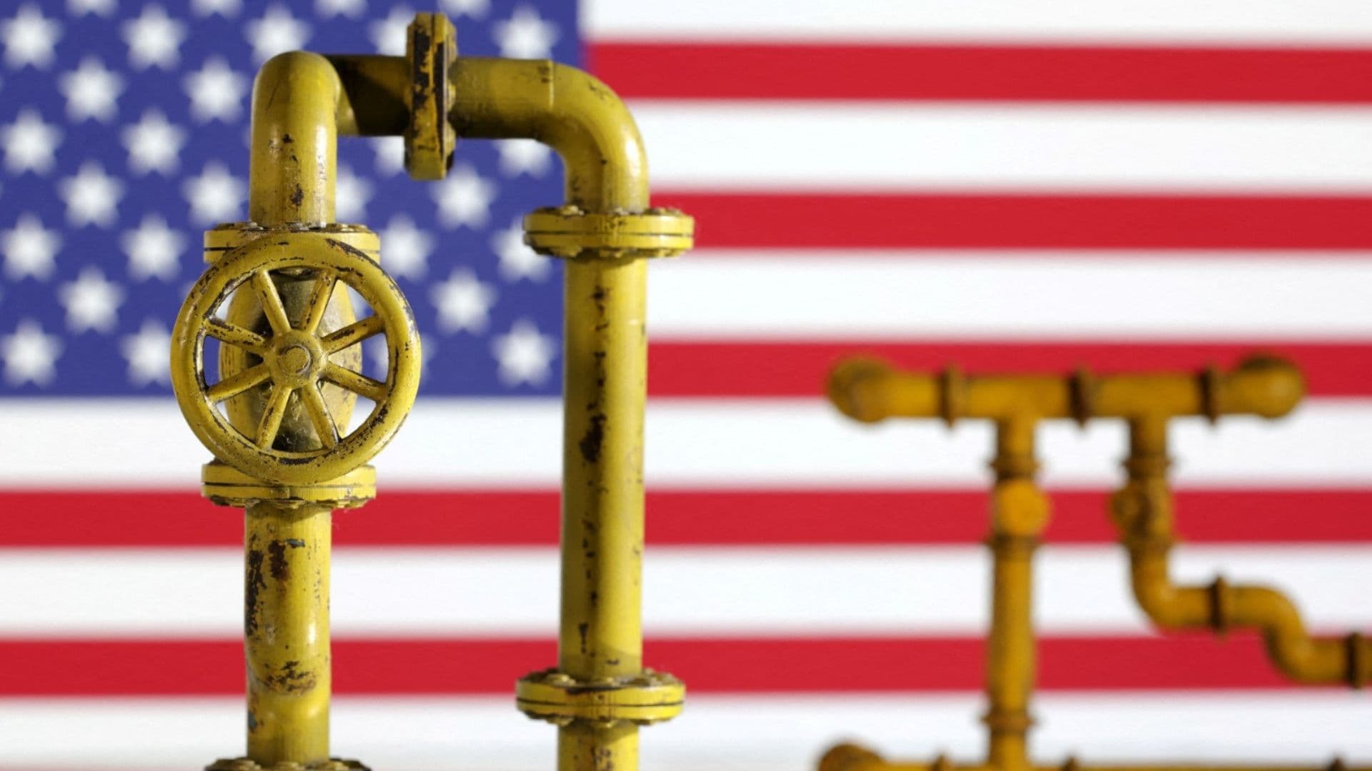 Maqueta de un gasoducto y la bandera de Estados Unidos