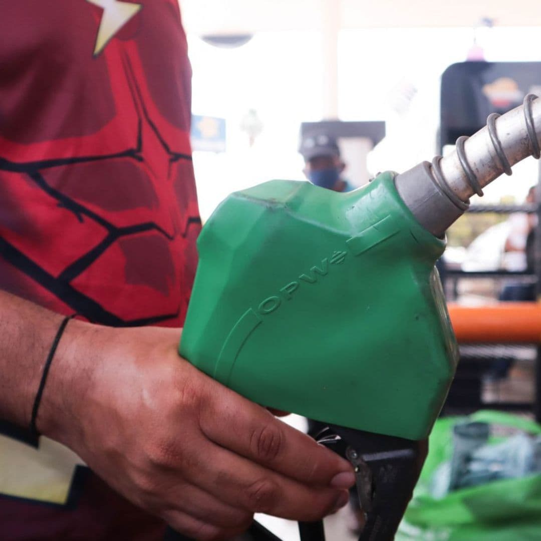 Hombre sujeta una manguera de combustible.