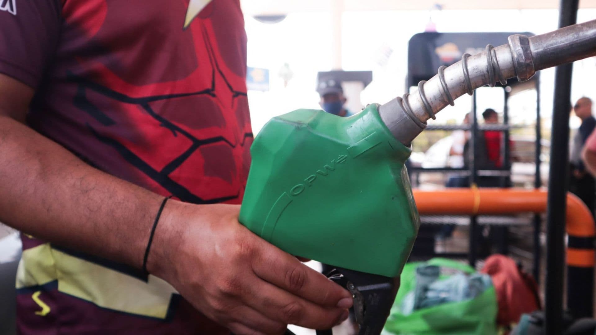Hombre sujeta una manguera de combustible.