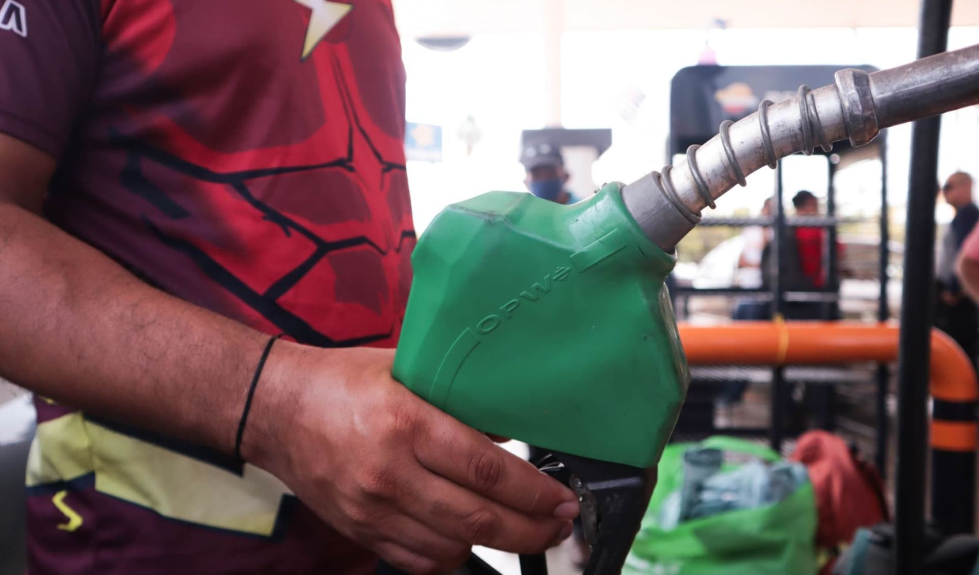 Hombre sujeta una manguera de combustible.