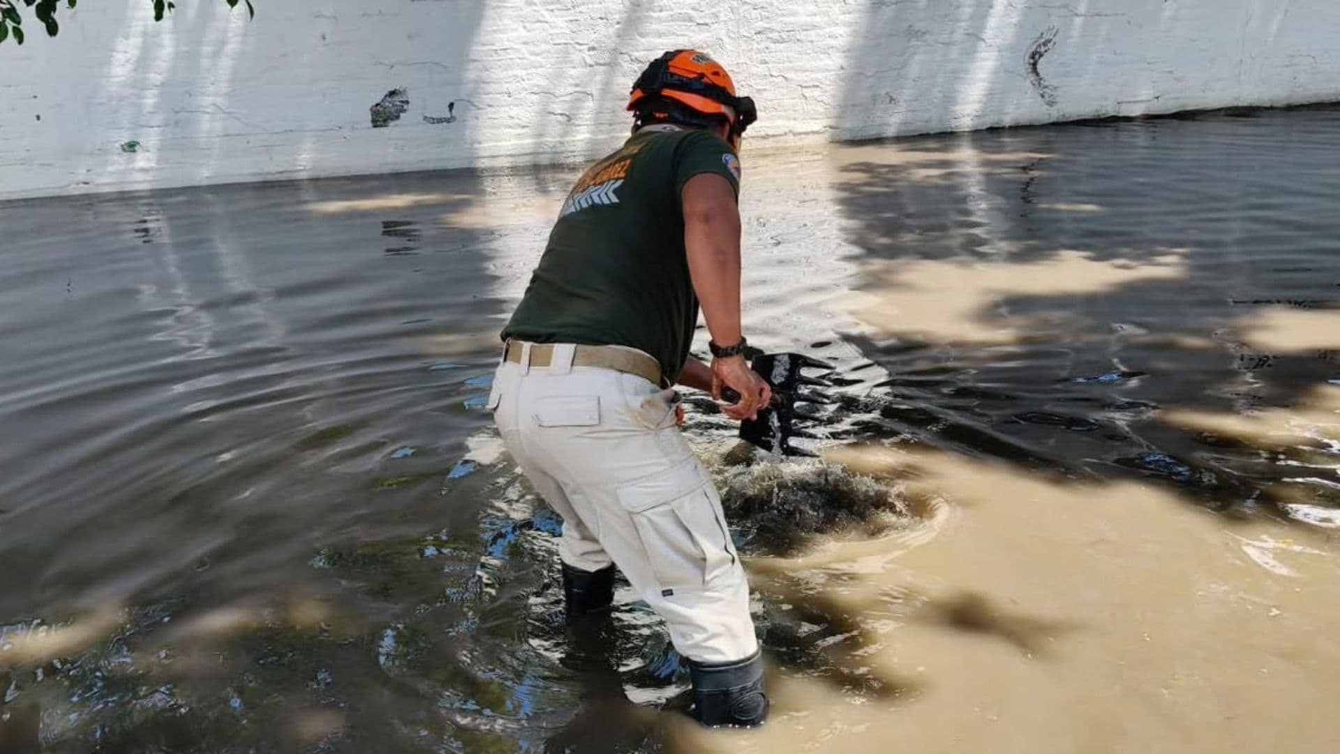 Un elemento de Protección Civil de Oaxaca intenta eliminar una anegación en la capital oaxaqueña
