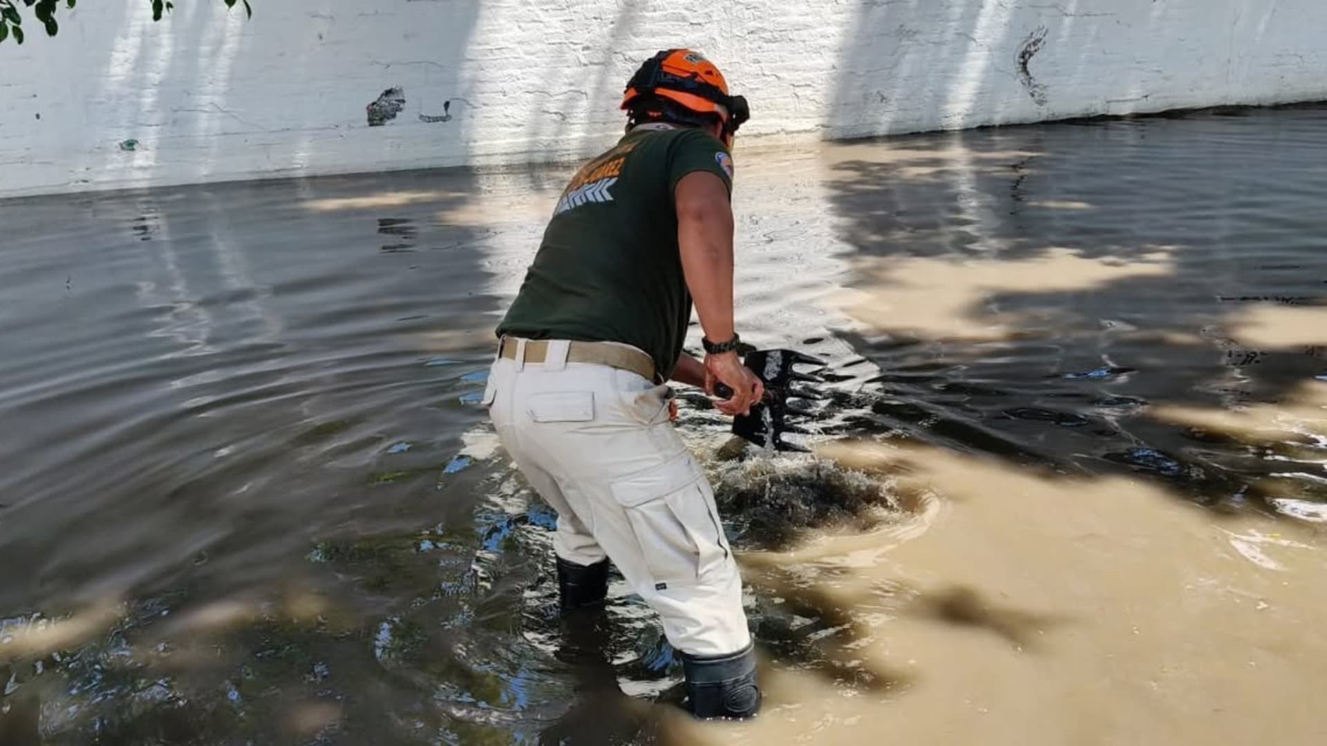 Un elemento de Protección Civil de Oaxaca intenta eliminar una anegación en la capital oaxaqueña